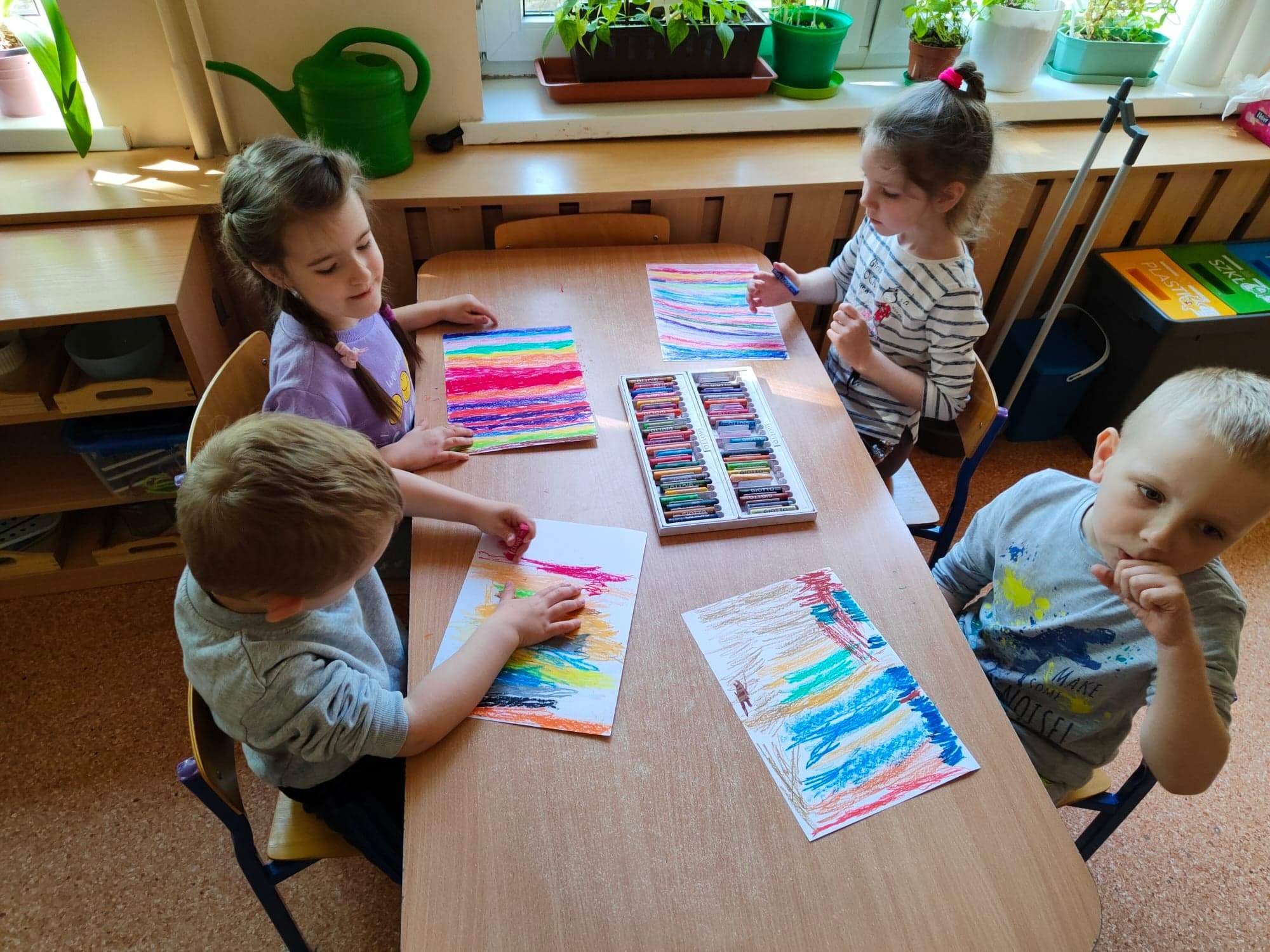 Dzieci zamalowują pastelami całą kartkę, przygotowują podkład do wydrapywanki.