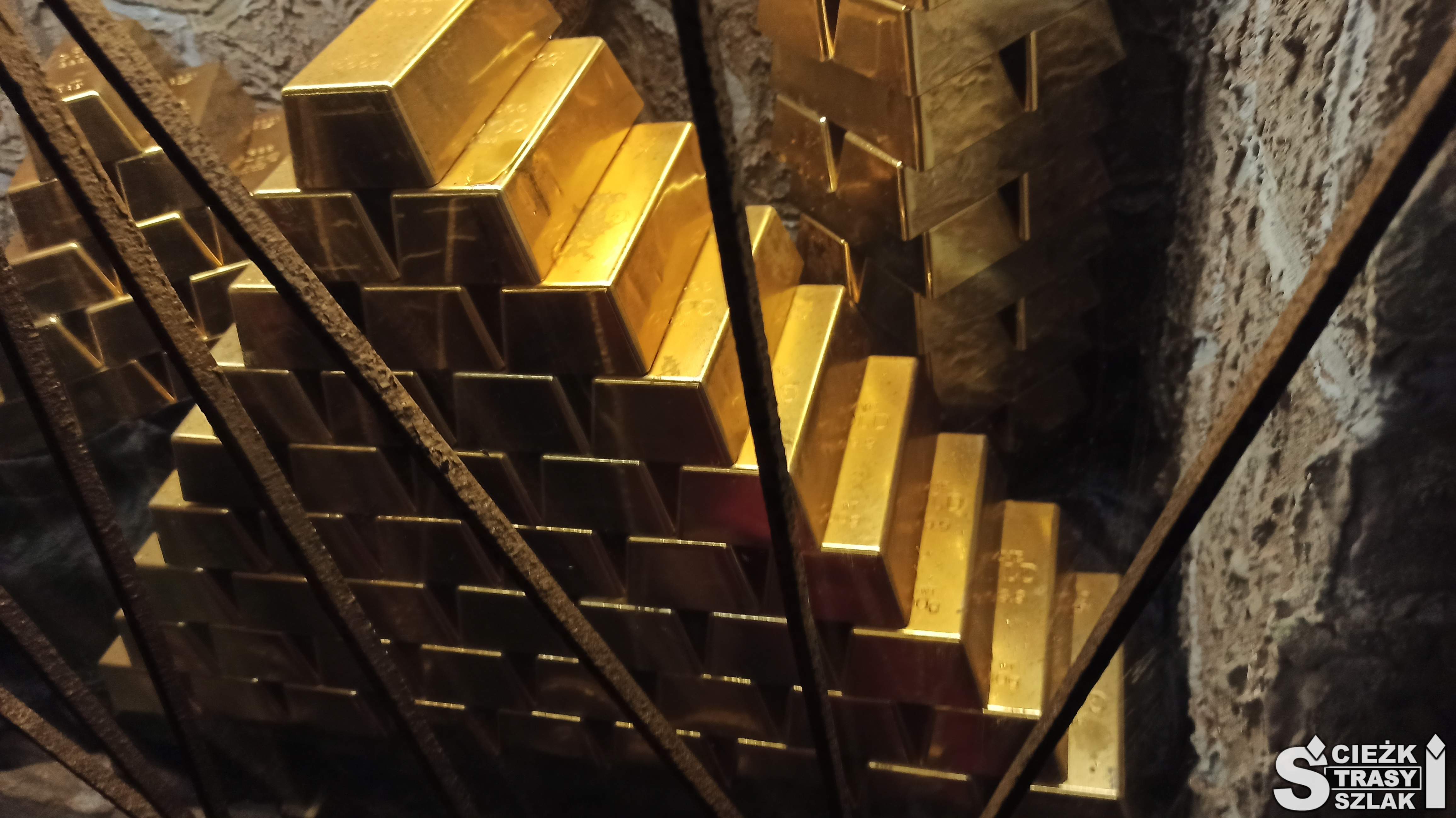 Piramida w złotym kolorze ułożona ze sztabek złota w kopalni w Złotym Stoku