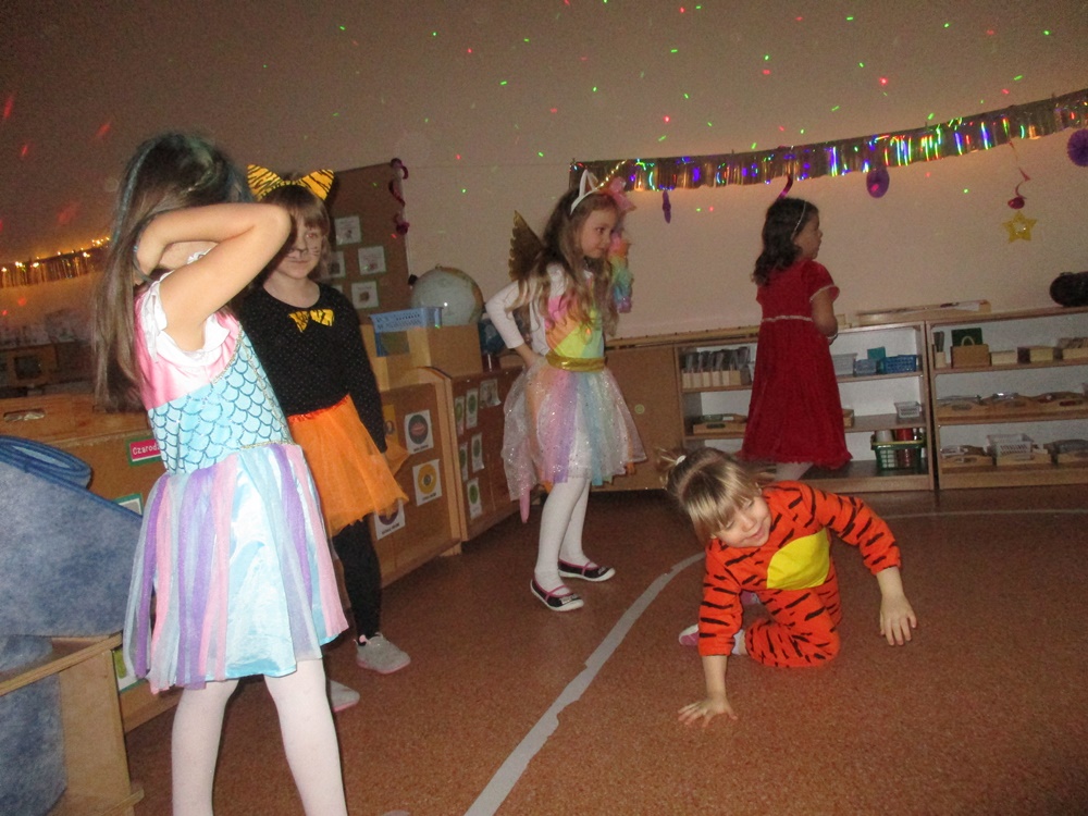 Bal karnawałowy u Jeżyków. Dzieci w kolorowych strojach : policjant, tygrysek, dynia, księżniczki.