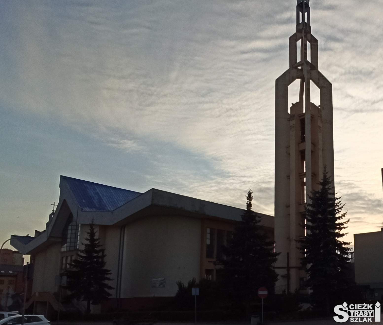 Sanktuarium w Jaworznie z wysoką wieżą kościelną dzwonnicą wieczorową porą