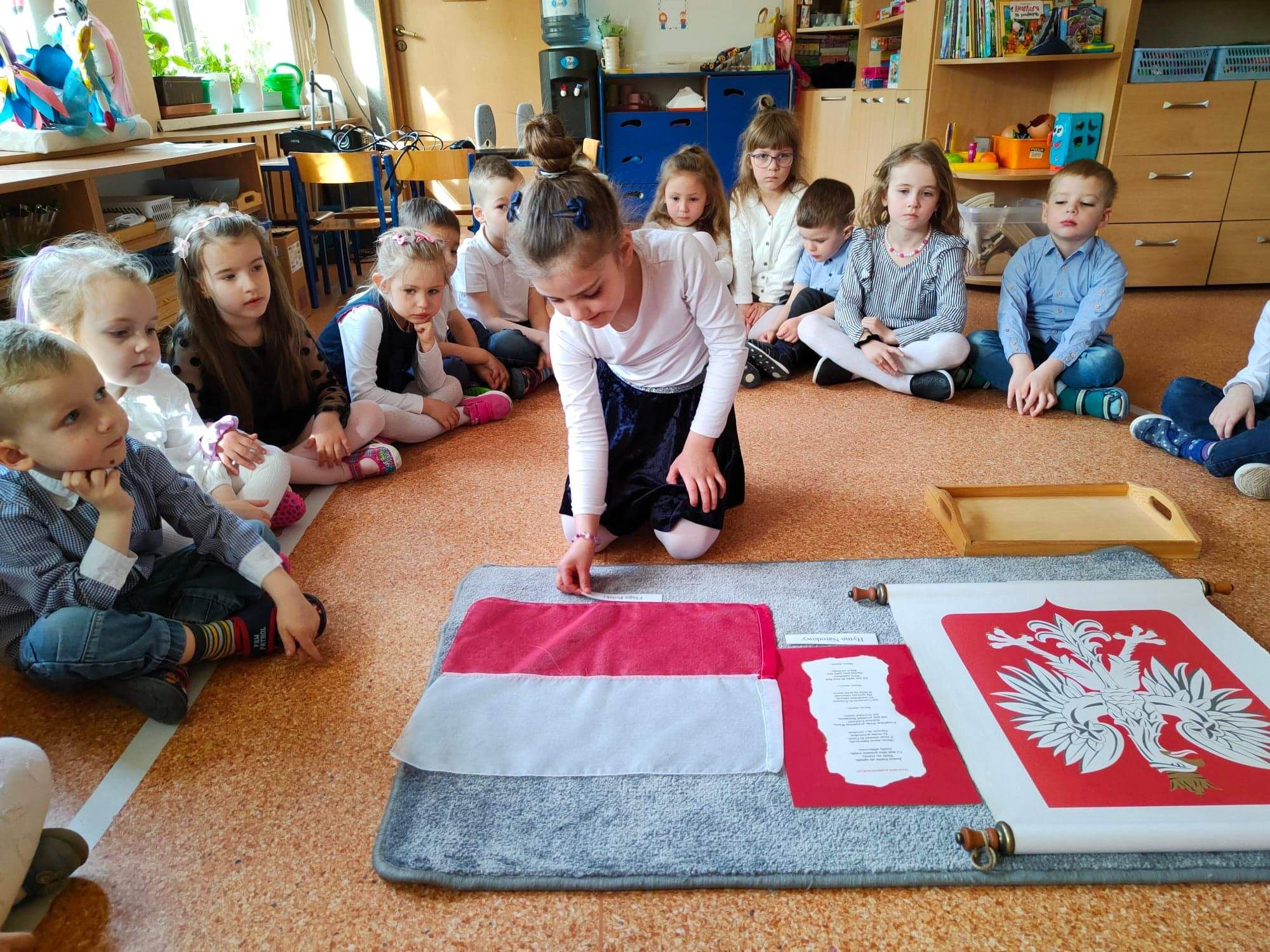 Dziewczynka dopasowuje podpis do symbolu narodowego - Flagi Polski.