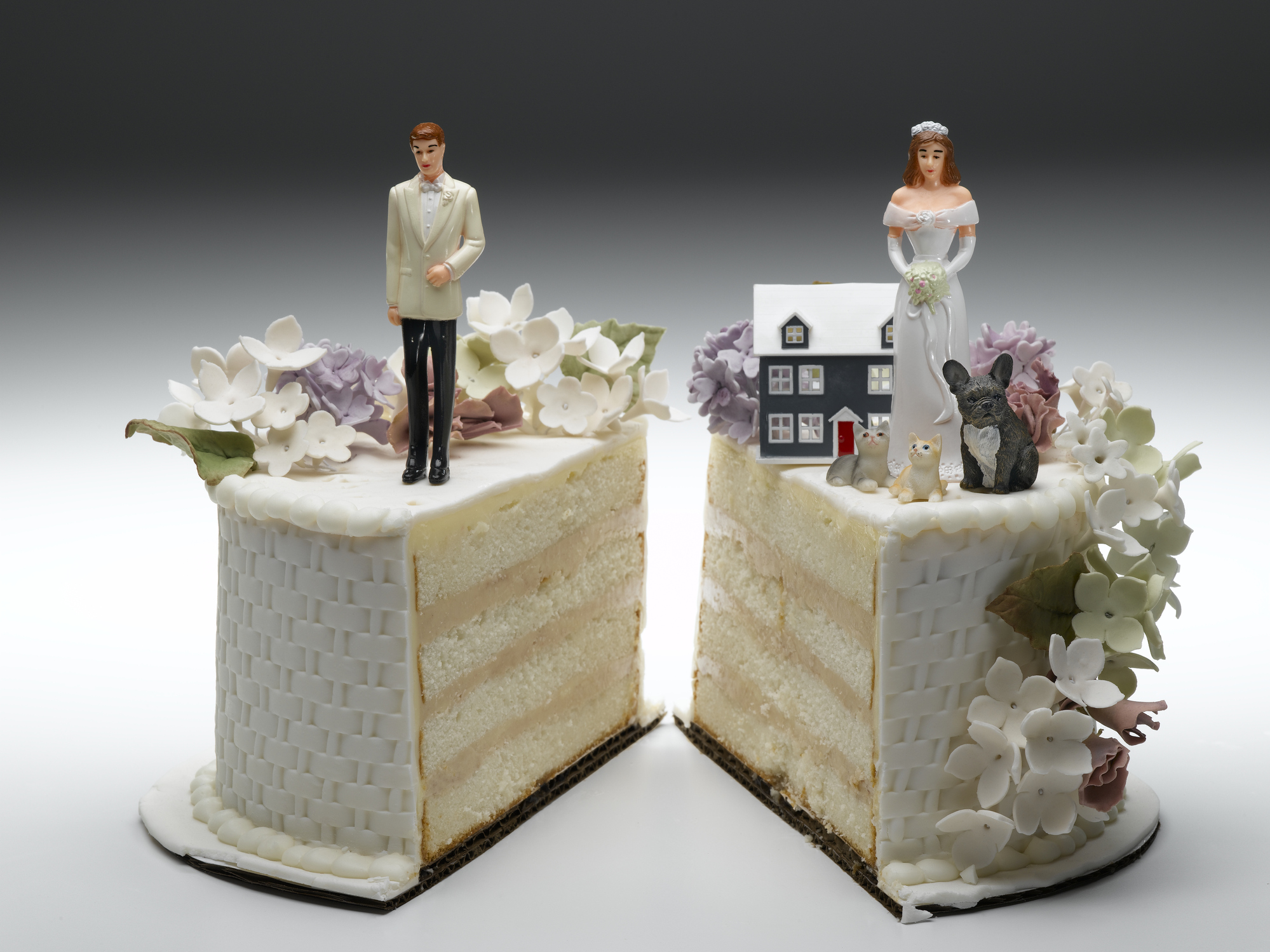 bride-and-groom-figurines-standing-on-two-separated-slices-of-wedding-cakejpg