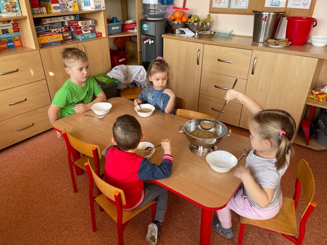 Dzieci z grupy BIEDRONKI siedzą przy stoliku i same  nalewają zupę z wazy