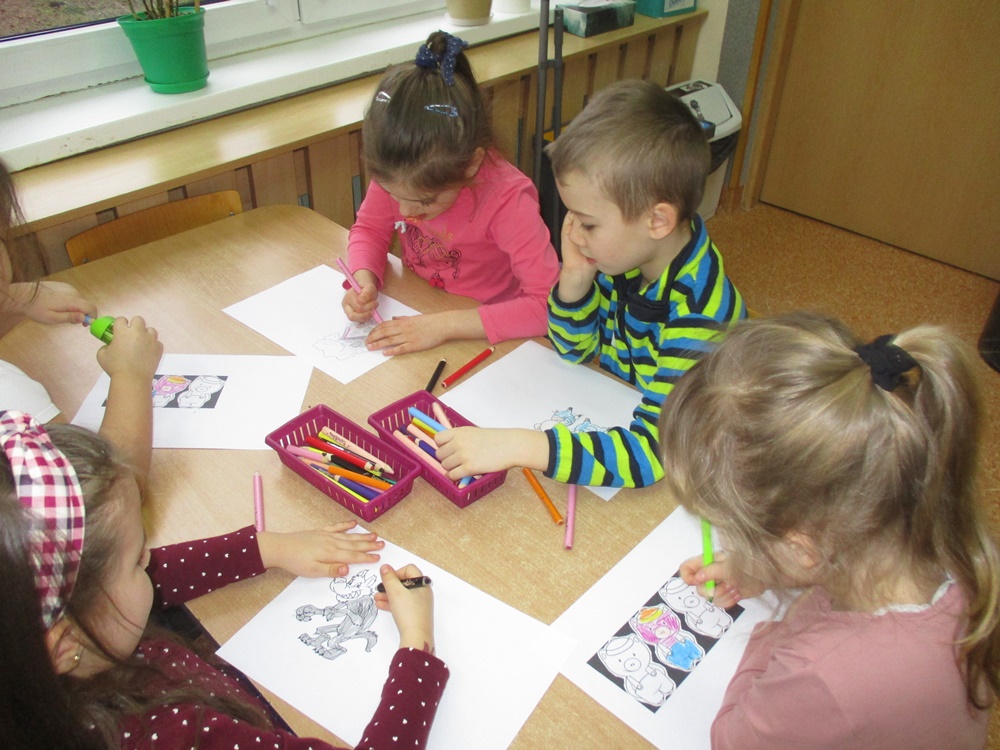 Dzieci wspólnie tworzą bajkową grę ścigankę. Kolorują, przyklejają kolorowe kółeczka.