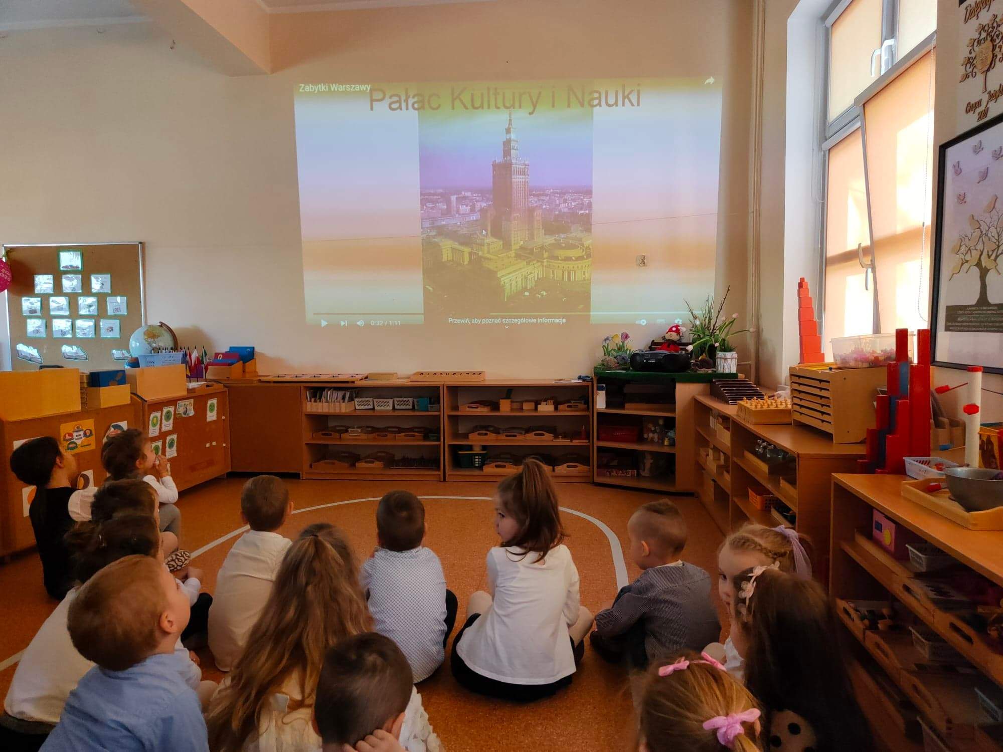 Dzieci słuchają informacji na temat Pałacu Kultury i Nauki.