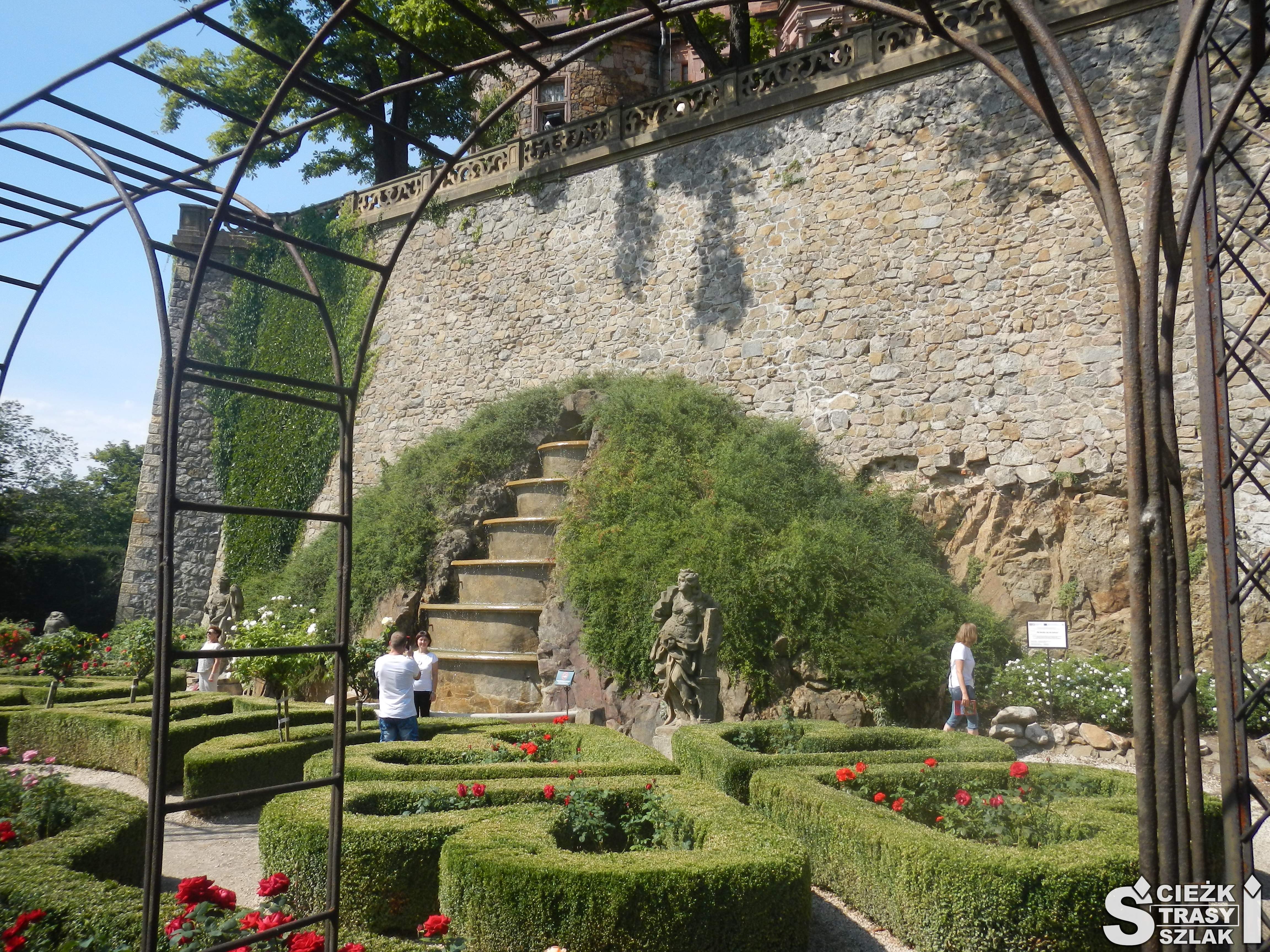 Wspaniałe rabaty kwiatowe w kształcie koła, serca przy fontannie i greckich pomnikach w ogrodach królewskich