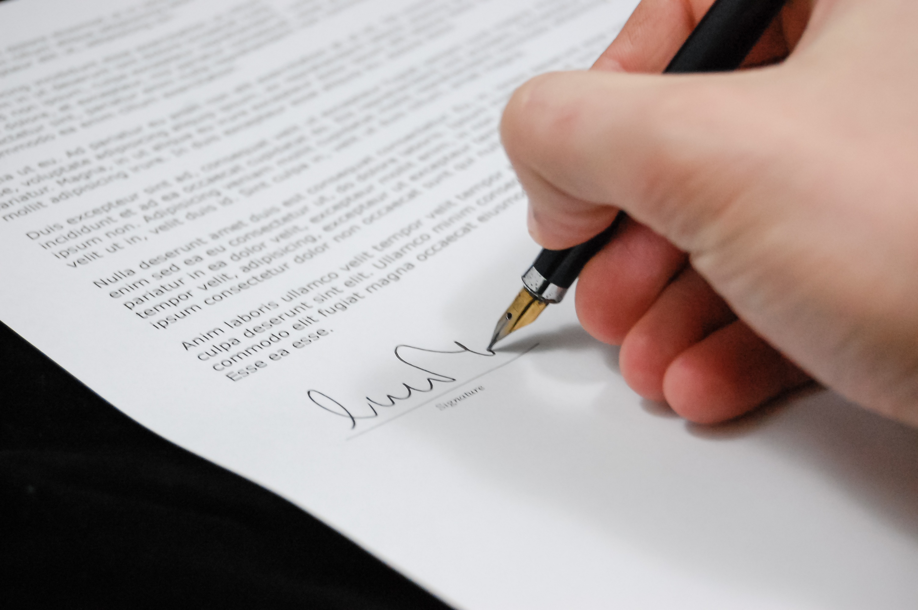 Zbliżenie na rękę podpisującą dokument