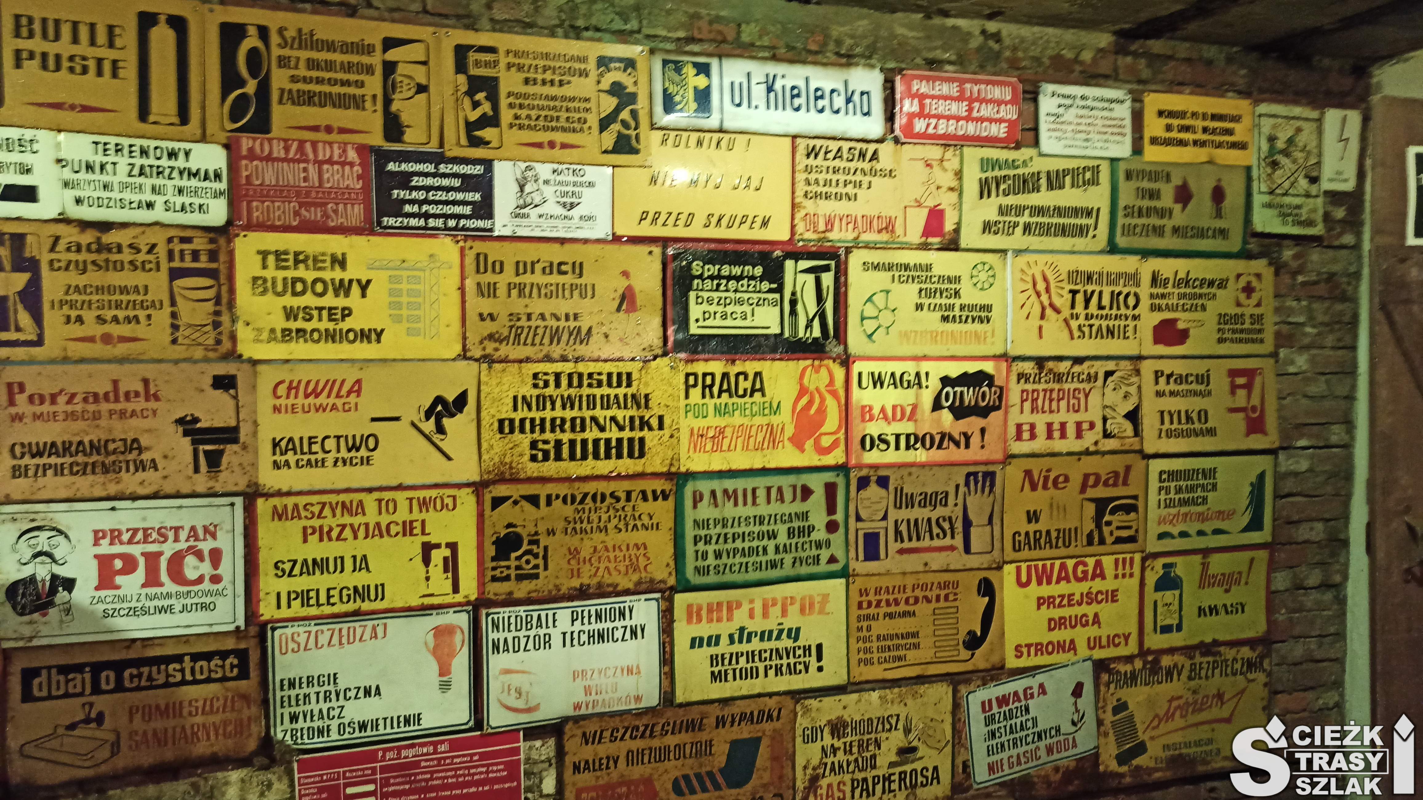 Ściana w kopalni ze śmiesznymi tabliczkami BHP, przestrogami i apelami z czasów PRLu należąca do muzeum
