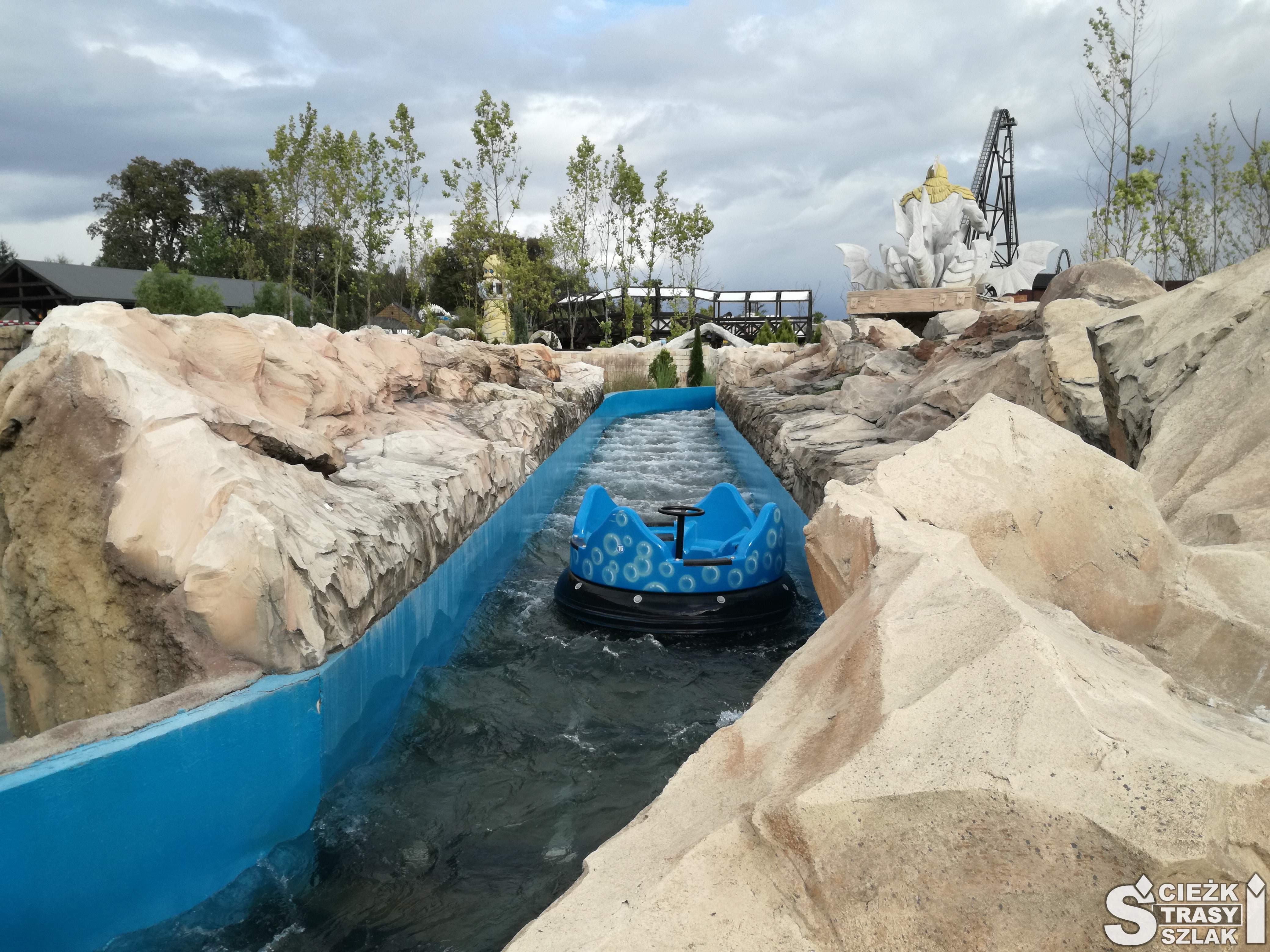Niebieski tor wypełniony wodą z niebieskim pontonem na cztery osoby między skałami w Energylandii