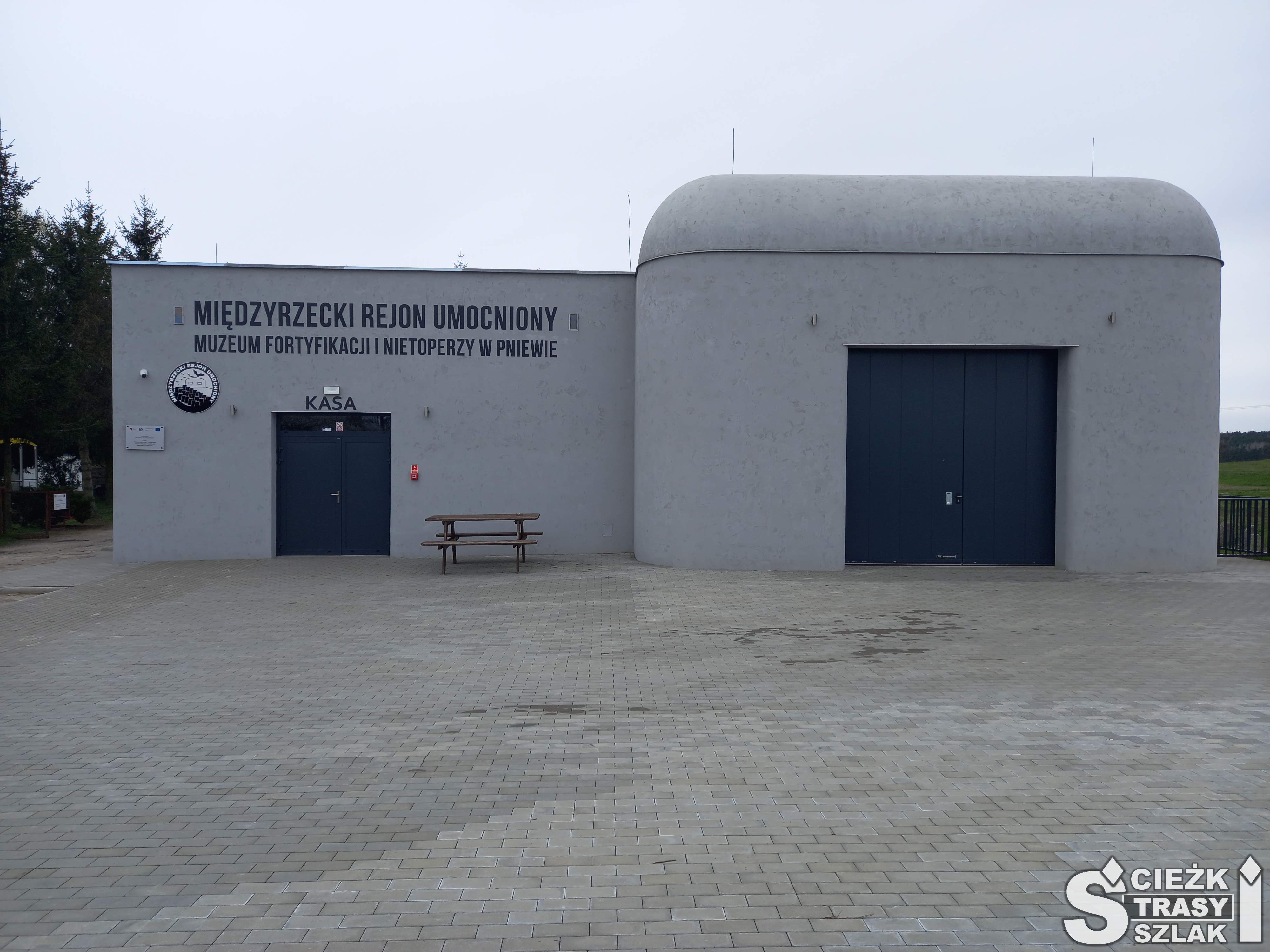 Drzwi wejściowe do Muzeum Fortyfikacji i Nietoperzy w Pniewie w betonowym bunkrze