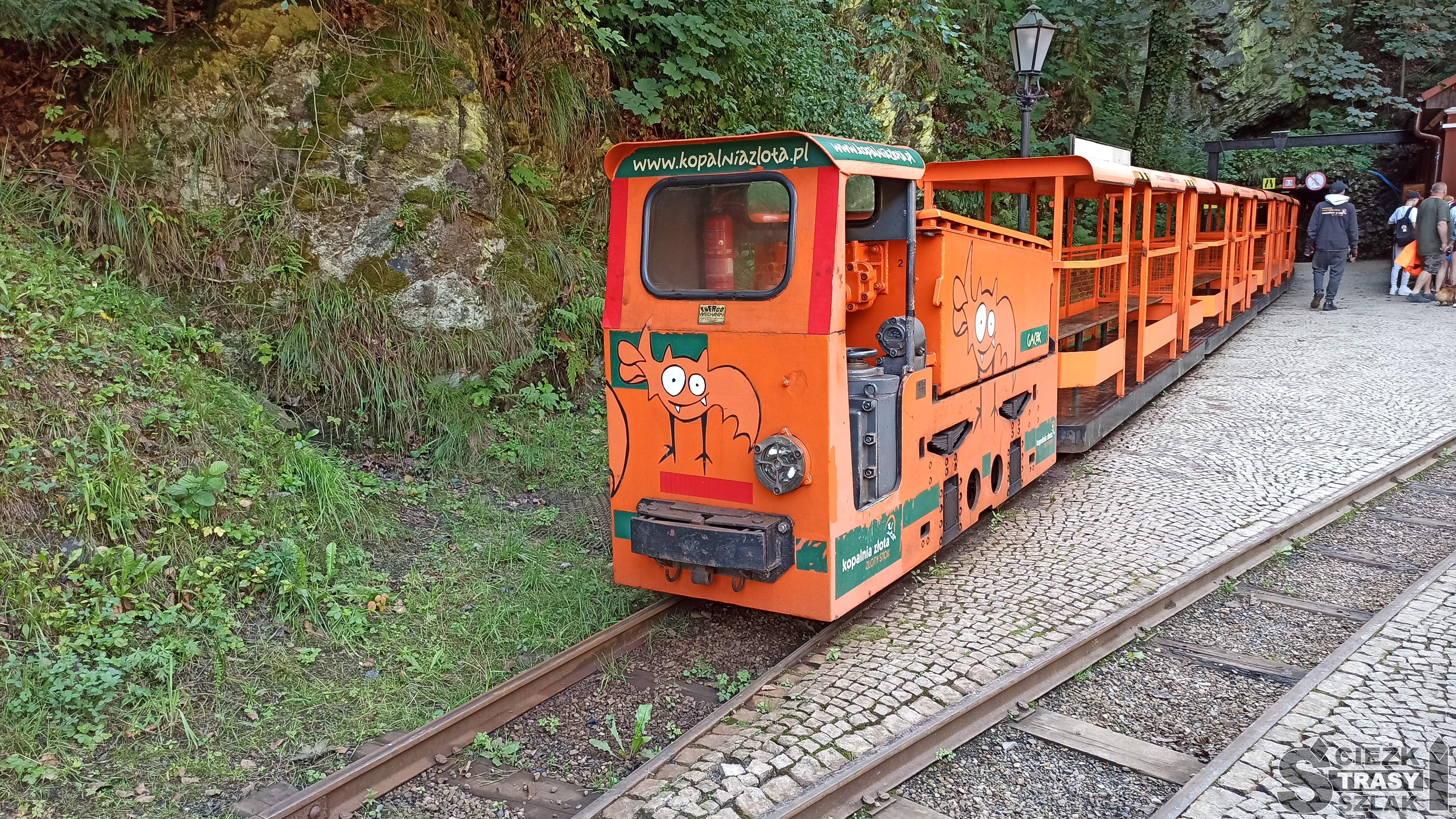 Pomarańczowy Tramwaj Podziemny wyjeżdżający ze sztolni Czarnej w kopalni złota