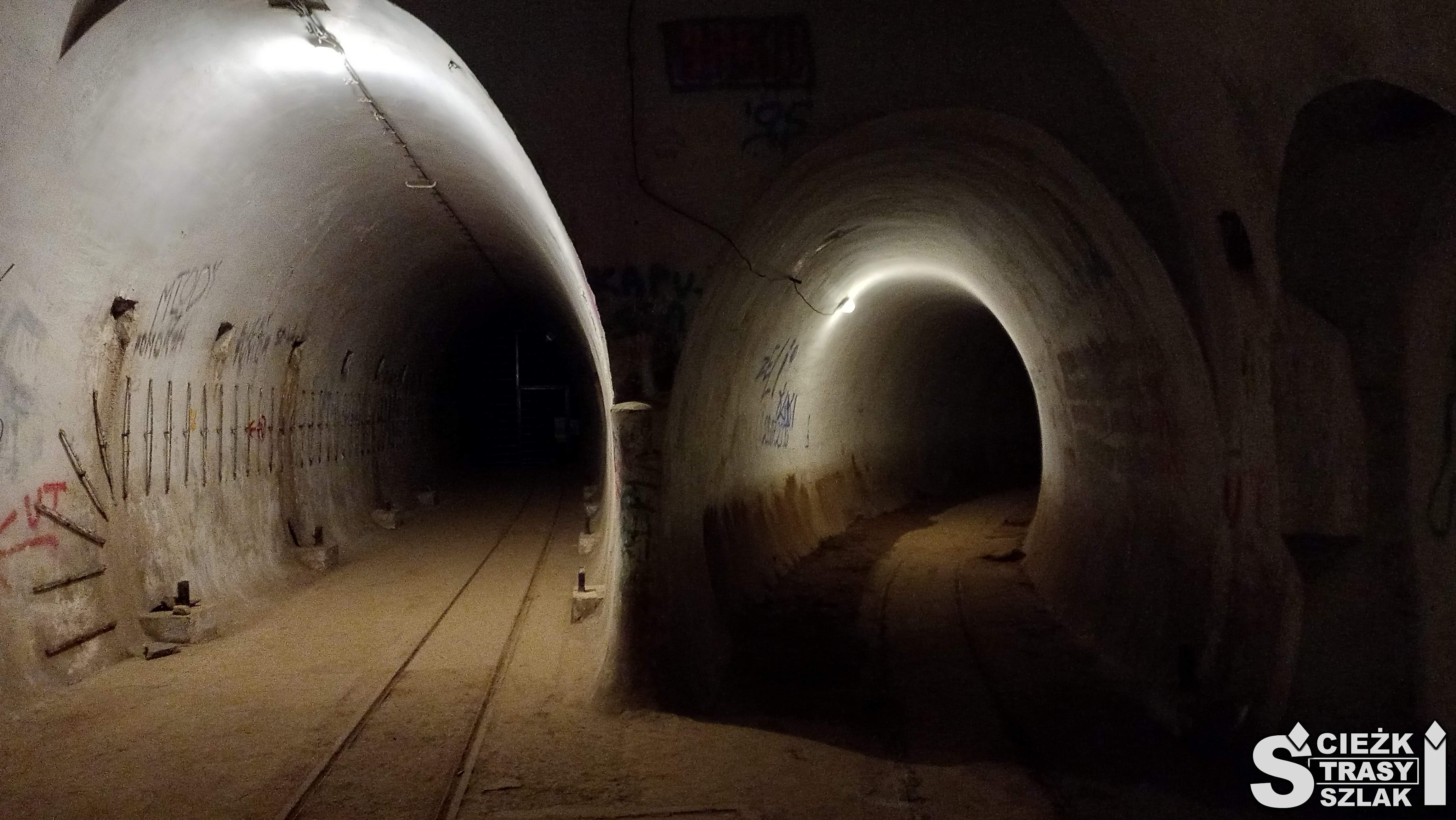 Dwa ciemne korytarze w bunkrach hitlerowskich z torami dla kolei wąskotorowej w Międzyrzeczu