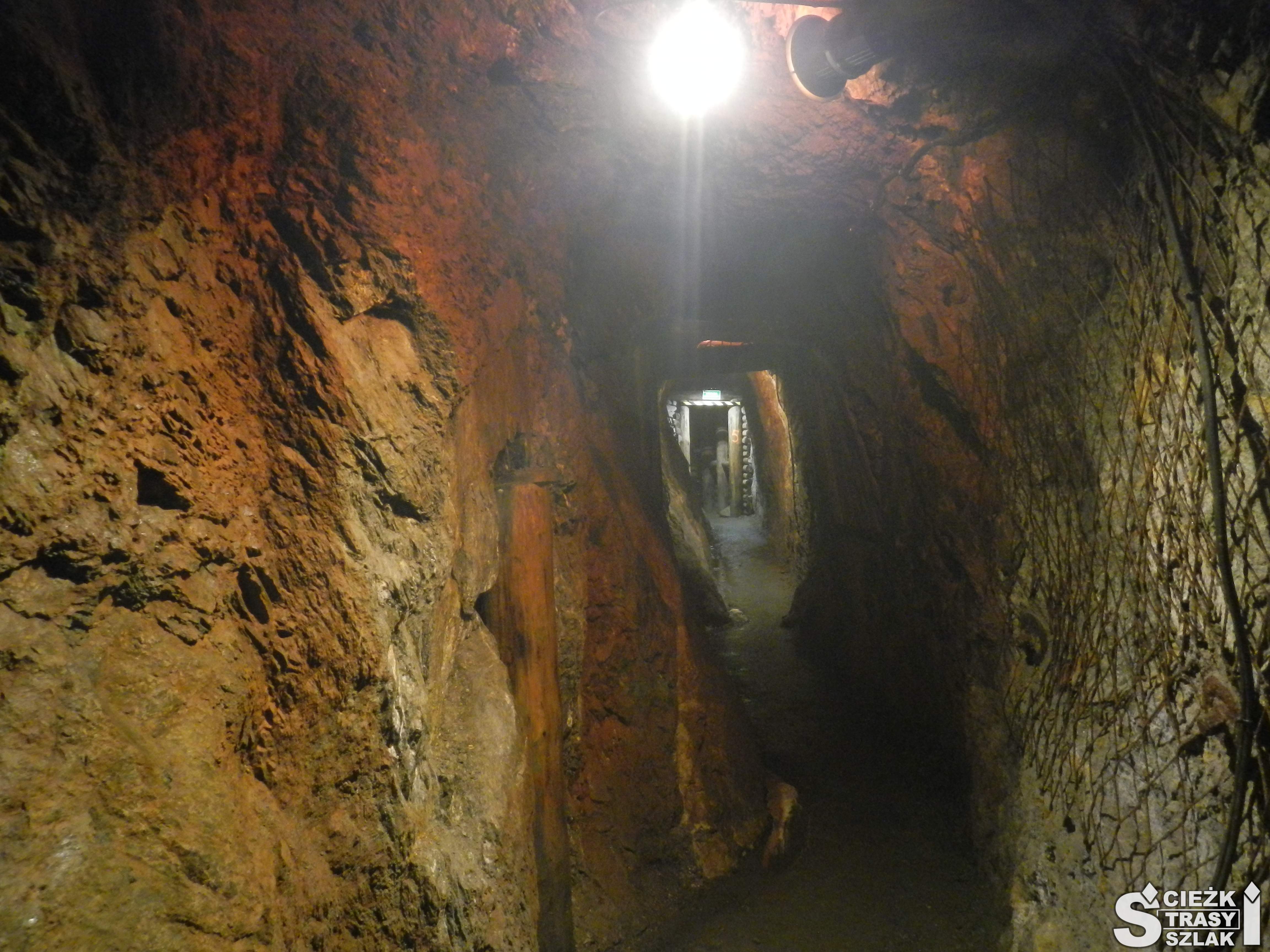 Wąski korytarz sztolni pokryty pigmentem ochra dającym odcień złoto czerwony