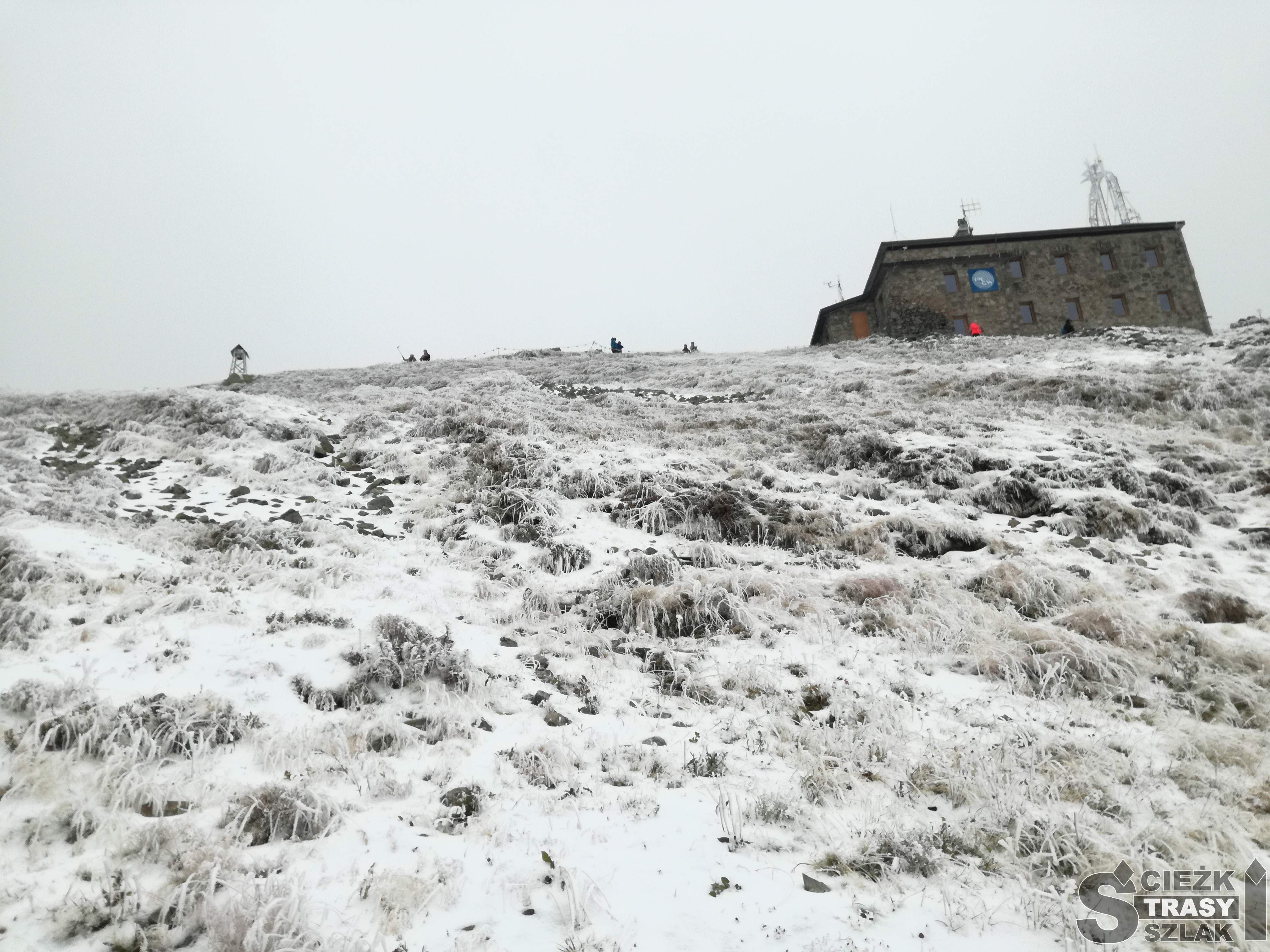 Stojący na pokrytym śniegiem szczycie Kasprowy Wierch budynek Obserwatorium IMGW w Zakopanem