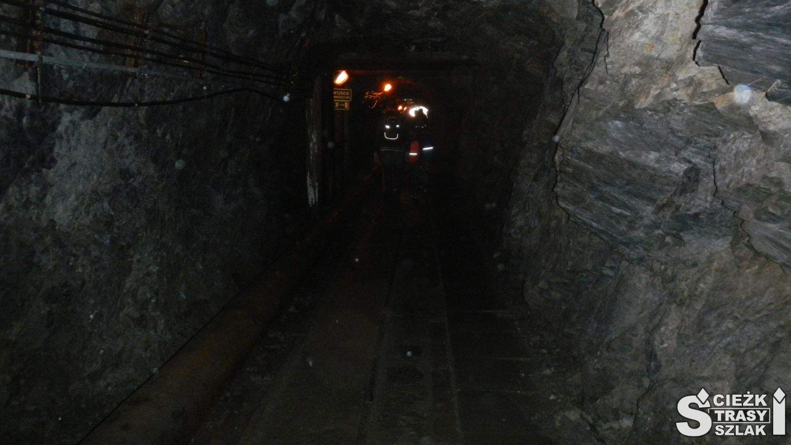 Chodnik górniczy ze światełkami w zalanym wodą tunelu wykorzystywanym do spływu łodzią