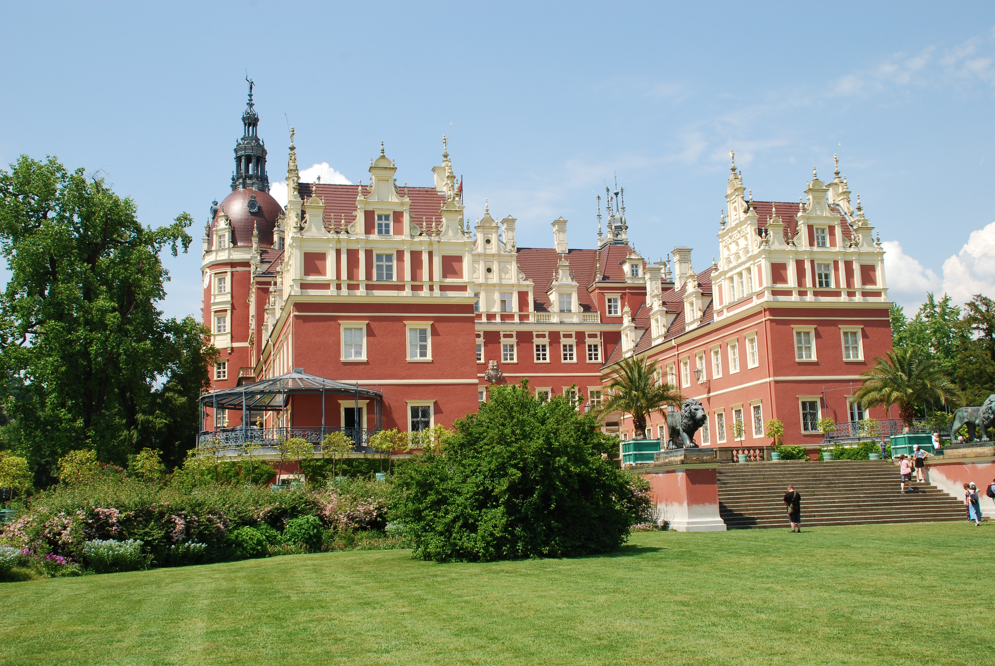 Zamek w Parku Mużakowskim po niemieckiej stronie z czerwoną elewacją i białymi gzymsami