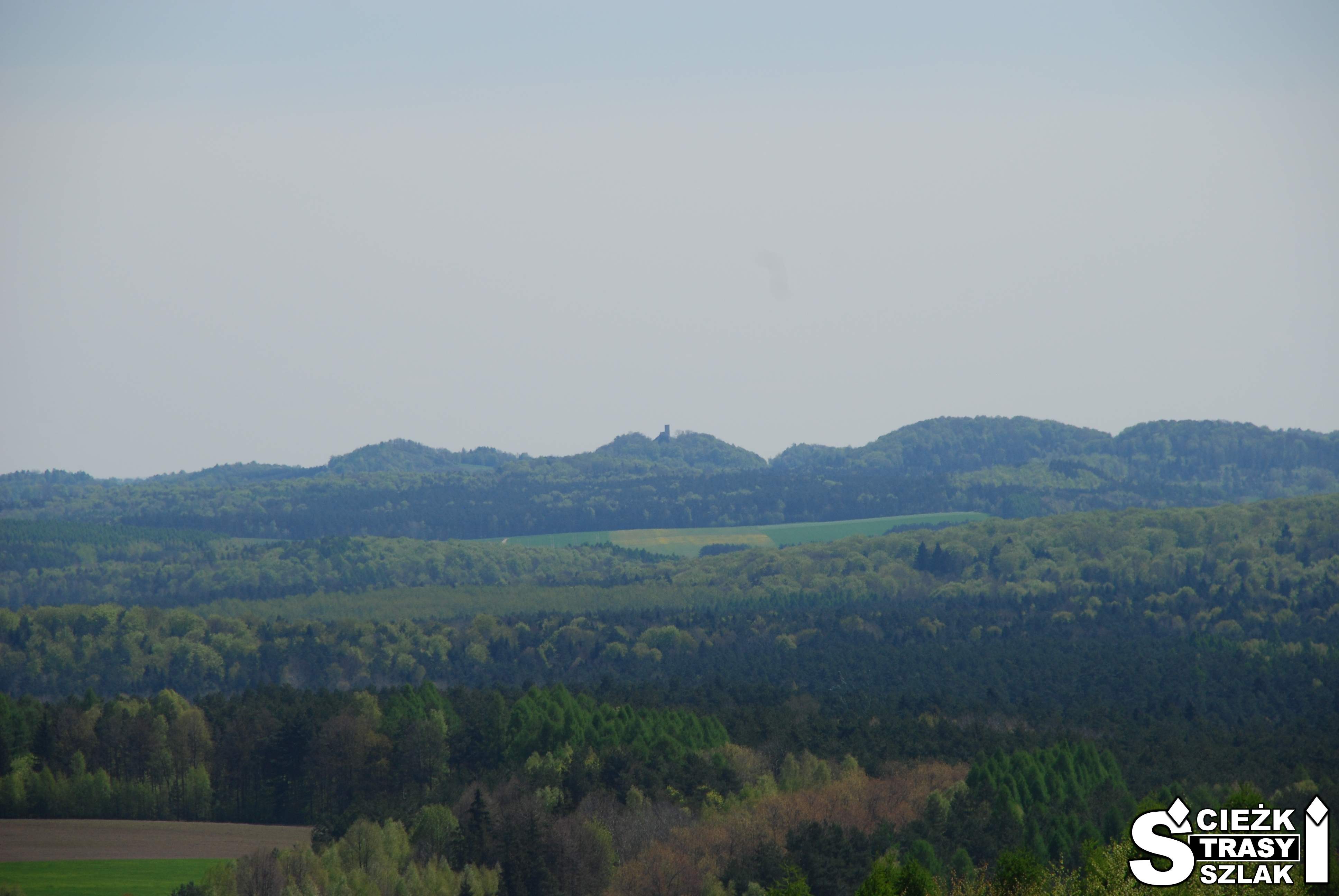 Górski krajobraz z miniaturą Zamku Smoleń w tle z punktu widokowego w Zamku Ogrodzieniec w podzamczu