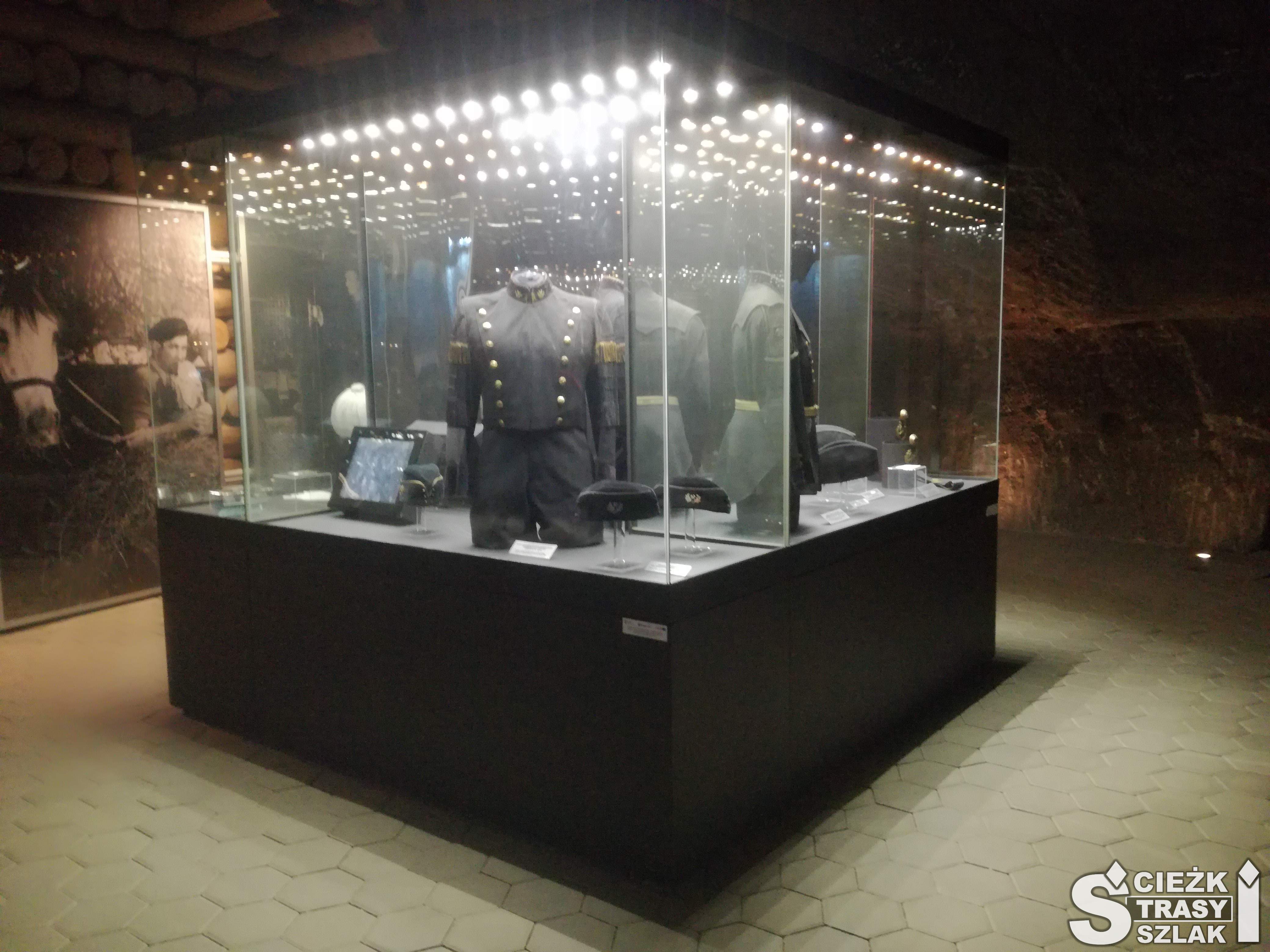 Podświetlona gablota z ekspozycją strojów  górniczych  w podziemnym Muzeum Żup Krakowskich w Wieliczce
