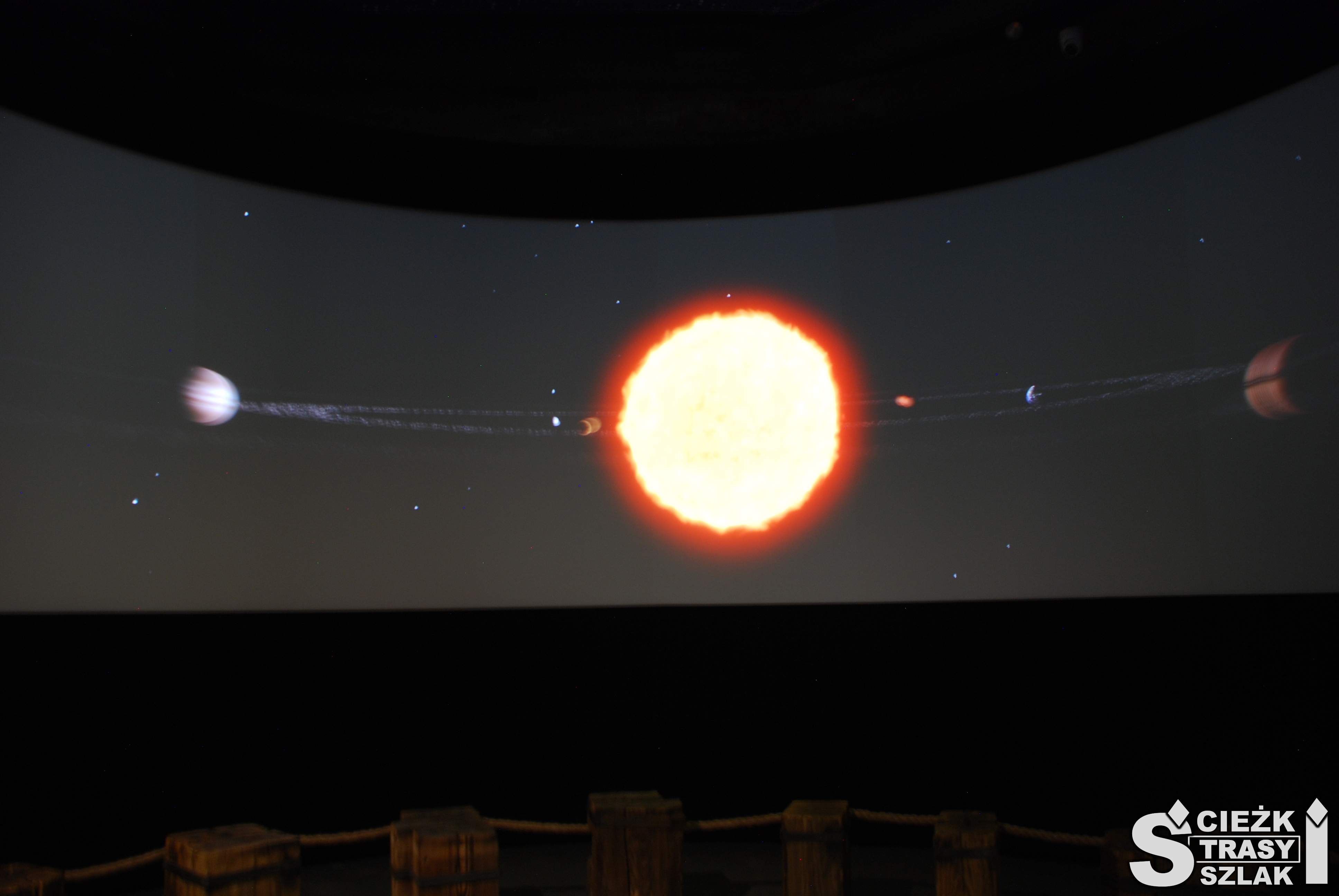 Duże słońce w otoczeniu planet układu słonecznego na szerokim ekranie w podziemnym muzeum w Olkuszu