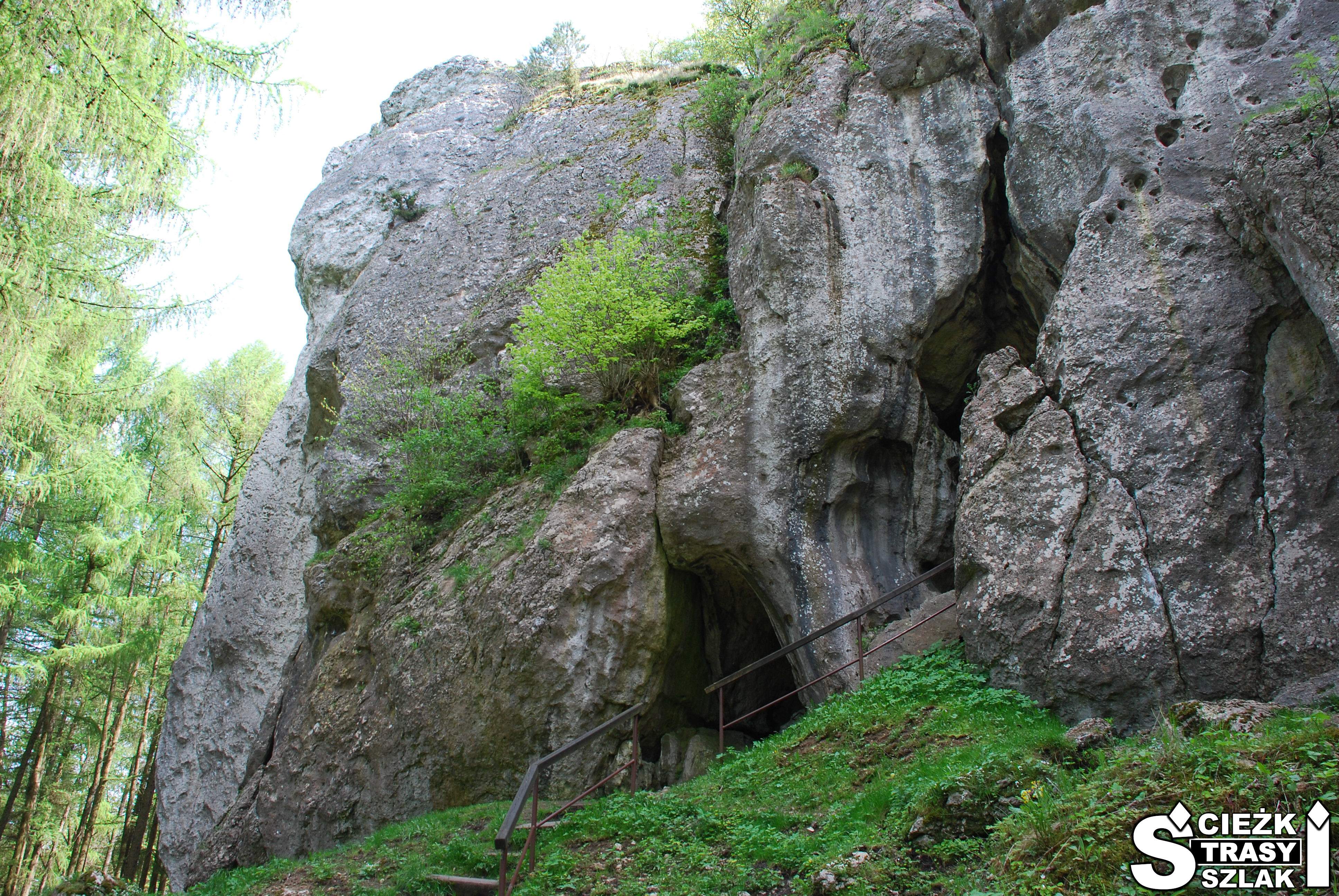 Strome schody z metalową barierką do groty i jaskini w skale wapiennej przy Grodzie Birów w Podzamczu