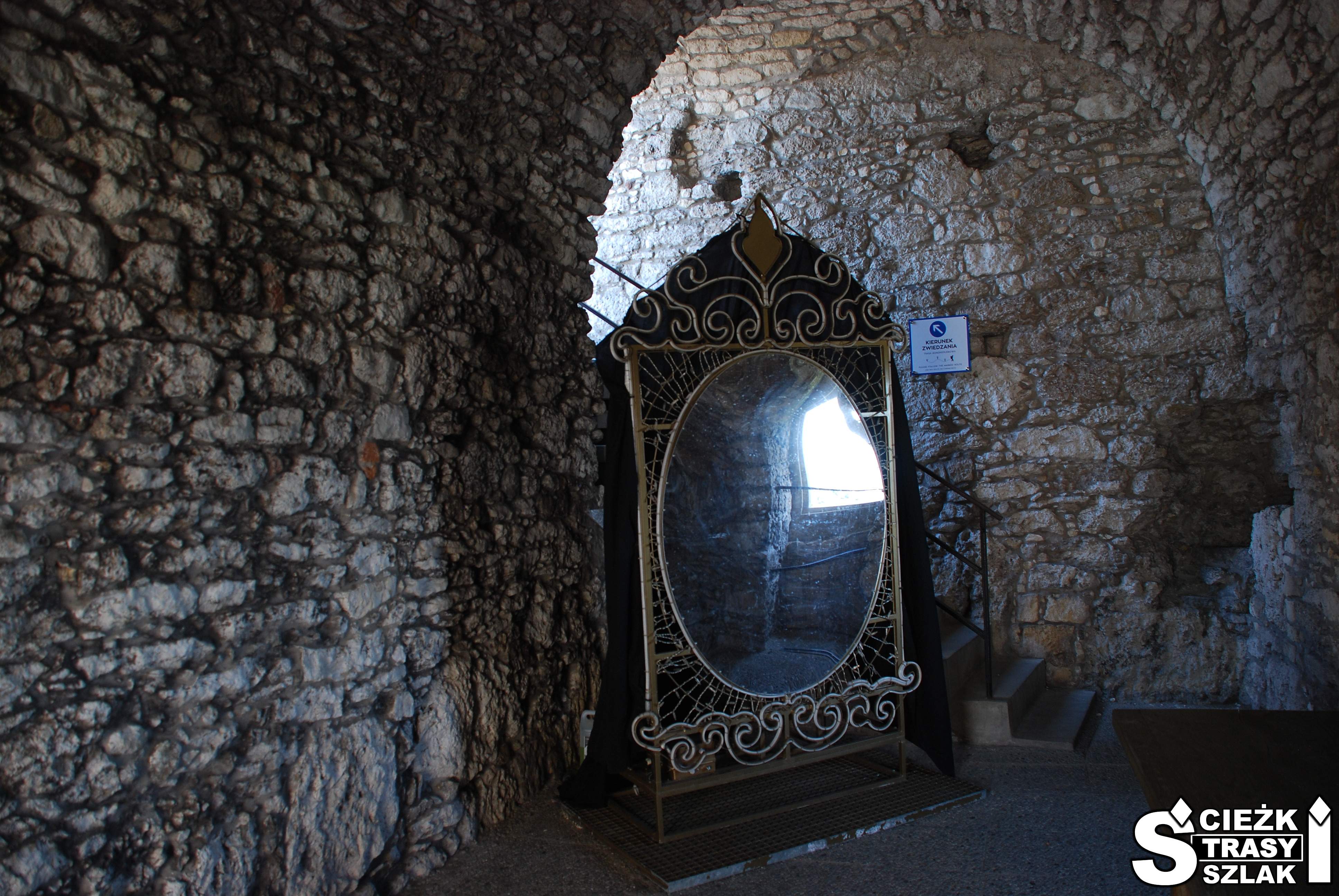 Duże lustro w metalowej, królewskiej ramie wewnątrz kamiennej komnaty Zamku Ogrodzieniec w Podzamczu
