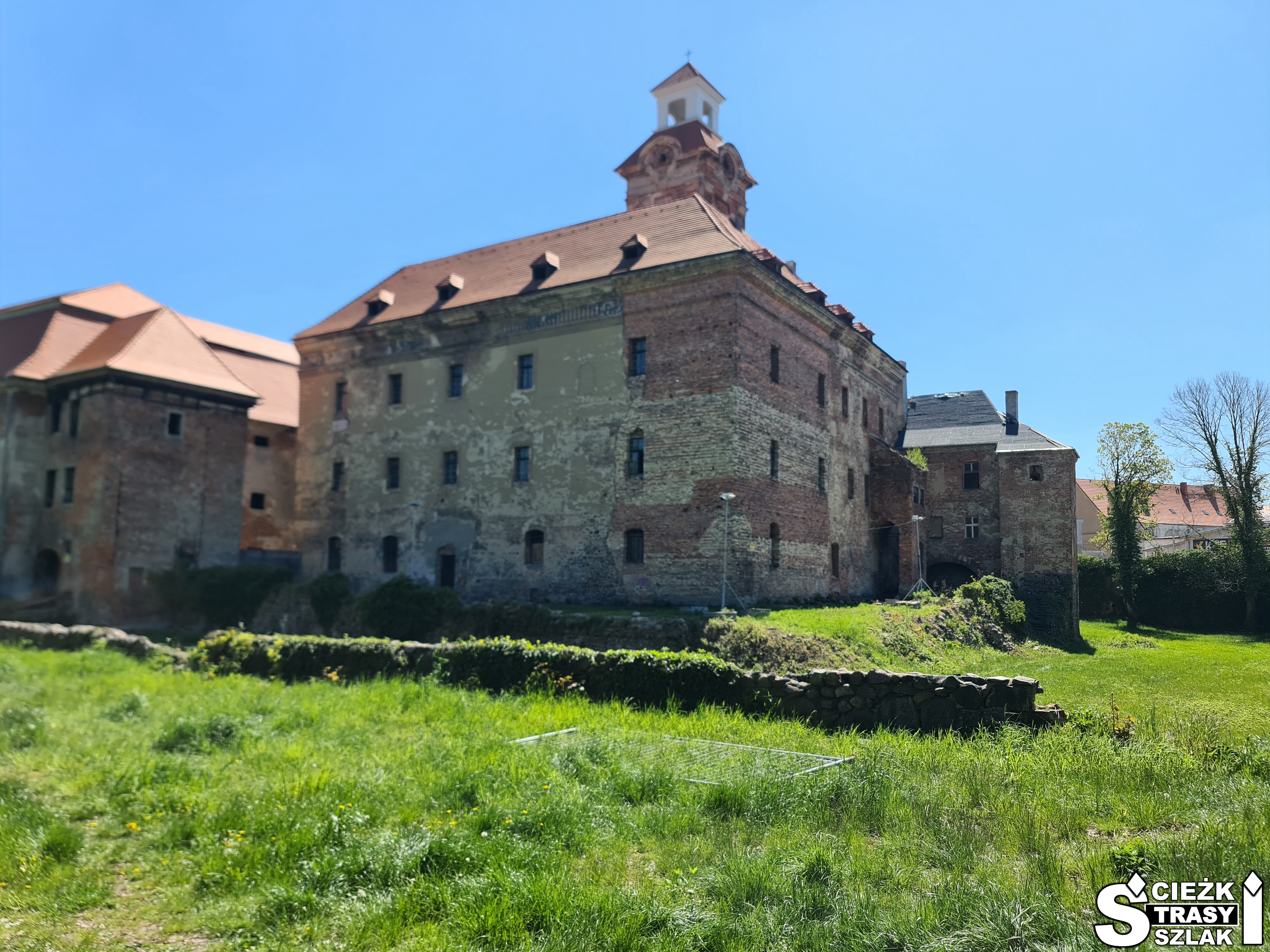 Zamek Dewinów-Bibersteinów w Żarach trzykondygnacyjny ze zniszczoną elewacją i wysoką wieżą