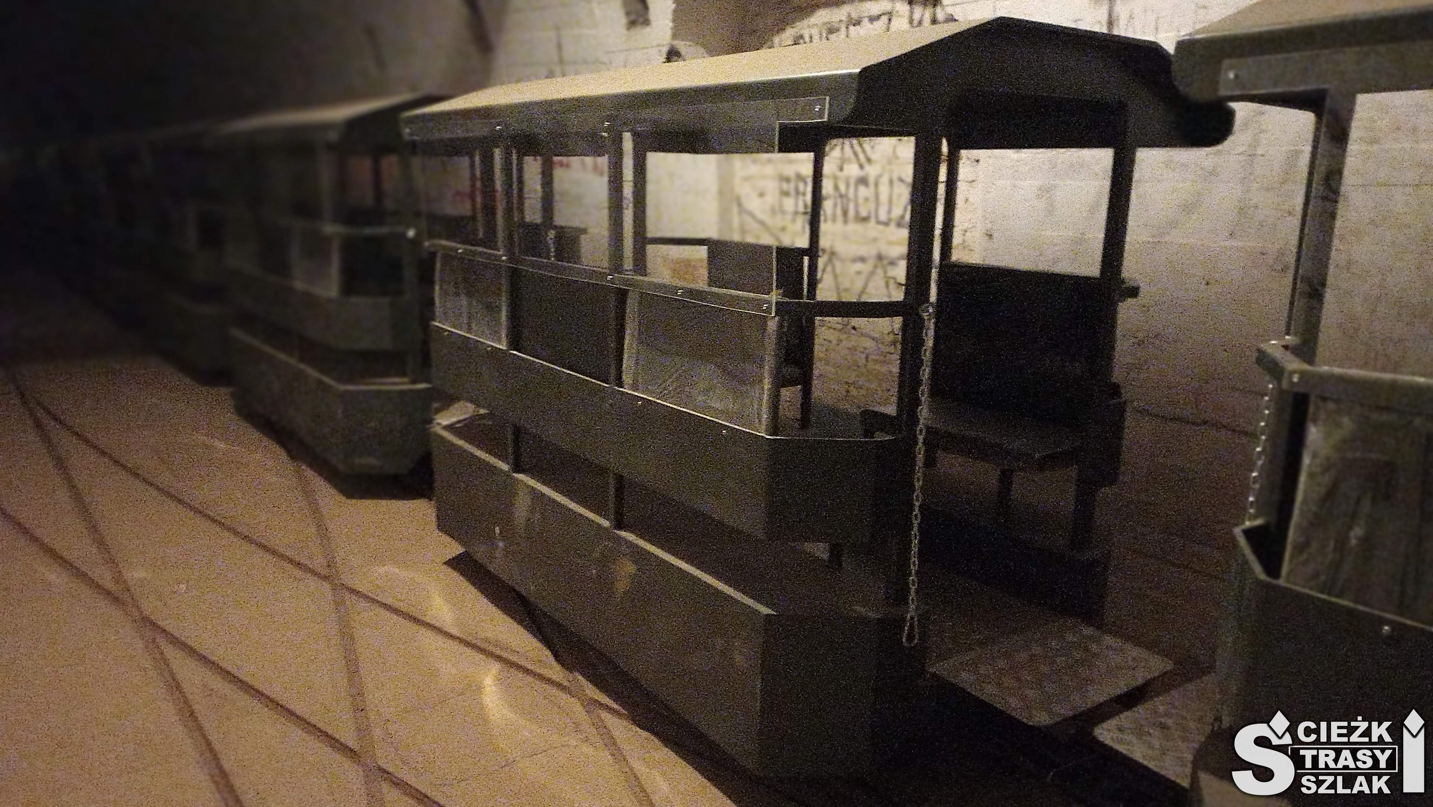 Słabo oświetlone wagony kolejki wąskotorowej w bunkrze hitlerowskim 30 metrów pod ziemią w Międzyrzeczu