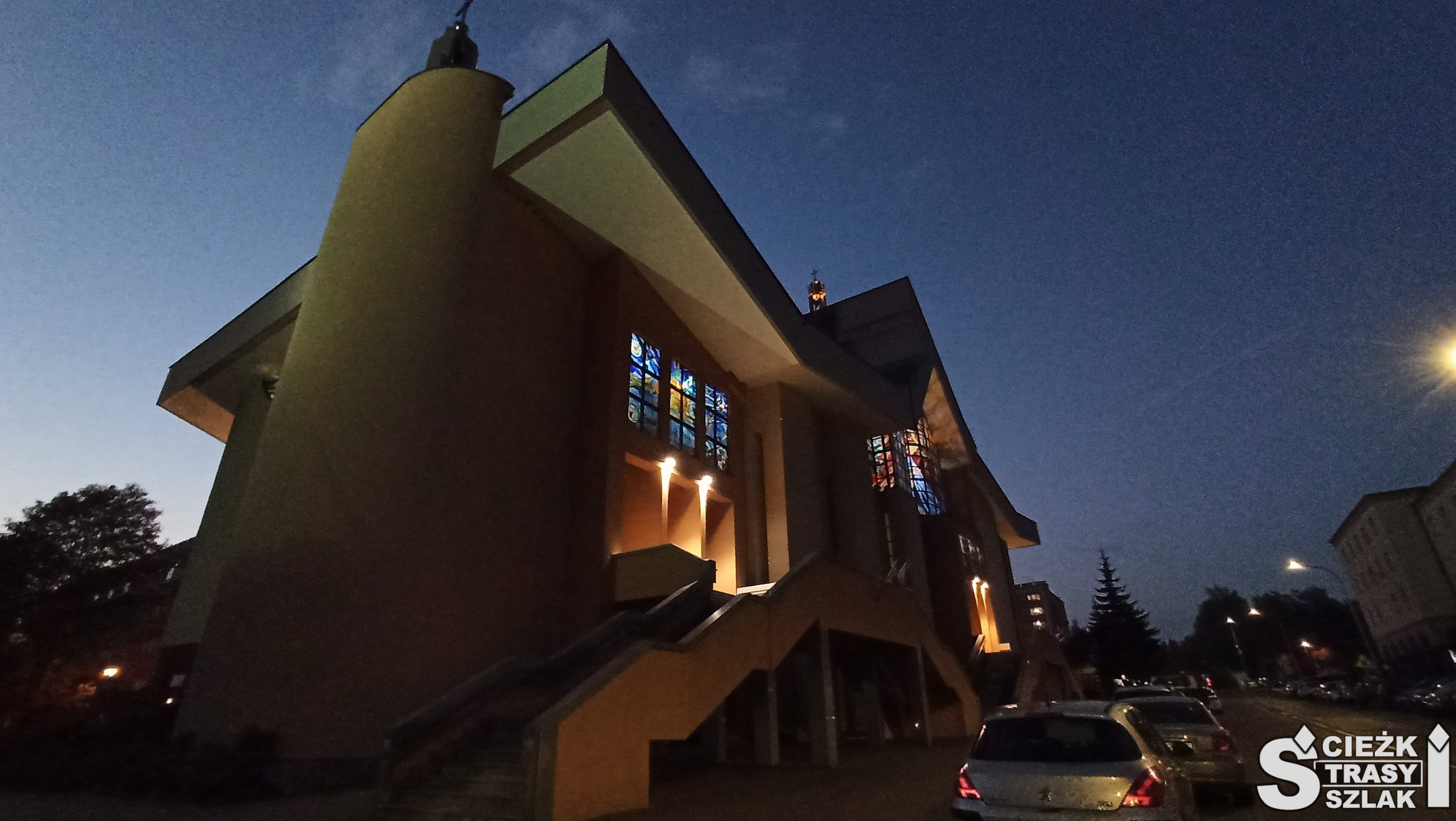 Nowoczesna świątynia pańska z fotowoltaiką na dachu kościoła i schodami do wnętrza Sanktuarium w Jaworznie wieczorową porą