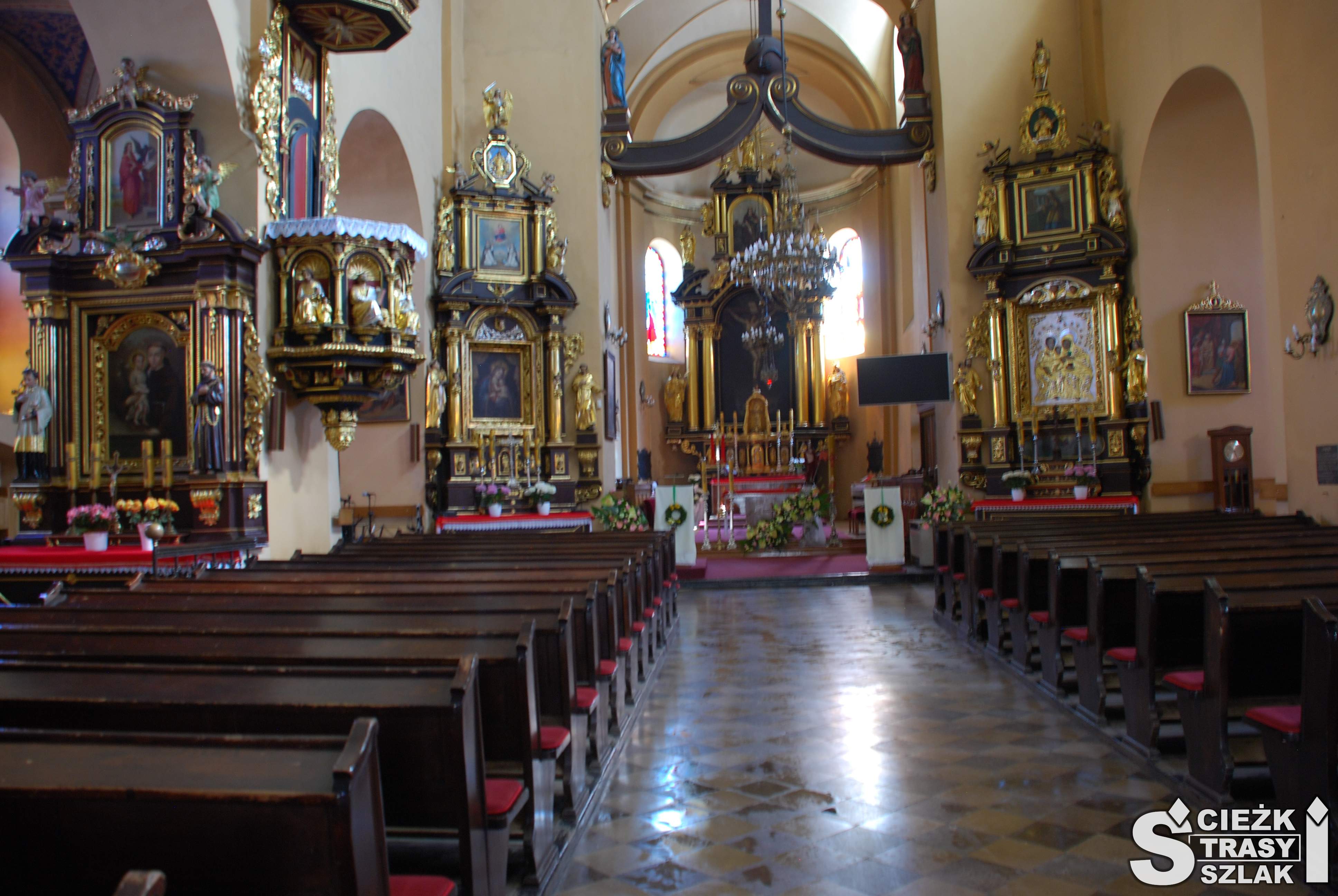 Zabytkowy ołtarz główny, pozłacana ambona i drewniane ławki w kościele katolickim w Wolbromiu pw. Św. Katarzyny