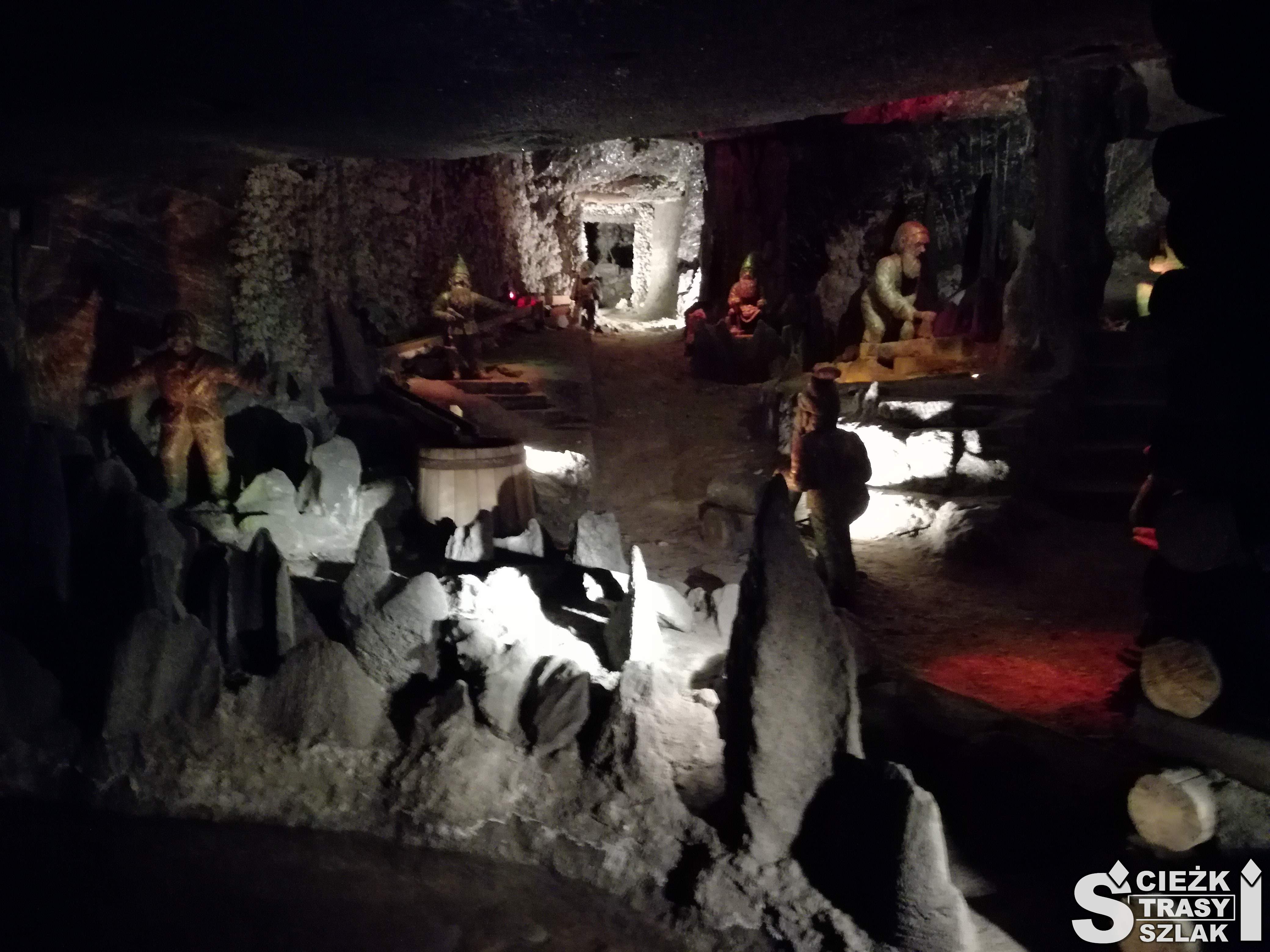 Ciemna wnęka wydrążona w ziemi w czasie eksploatacji soli w Wieliczce z ekspozycją figur i postaci górników