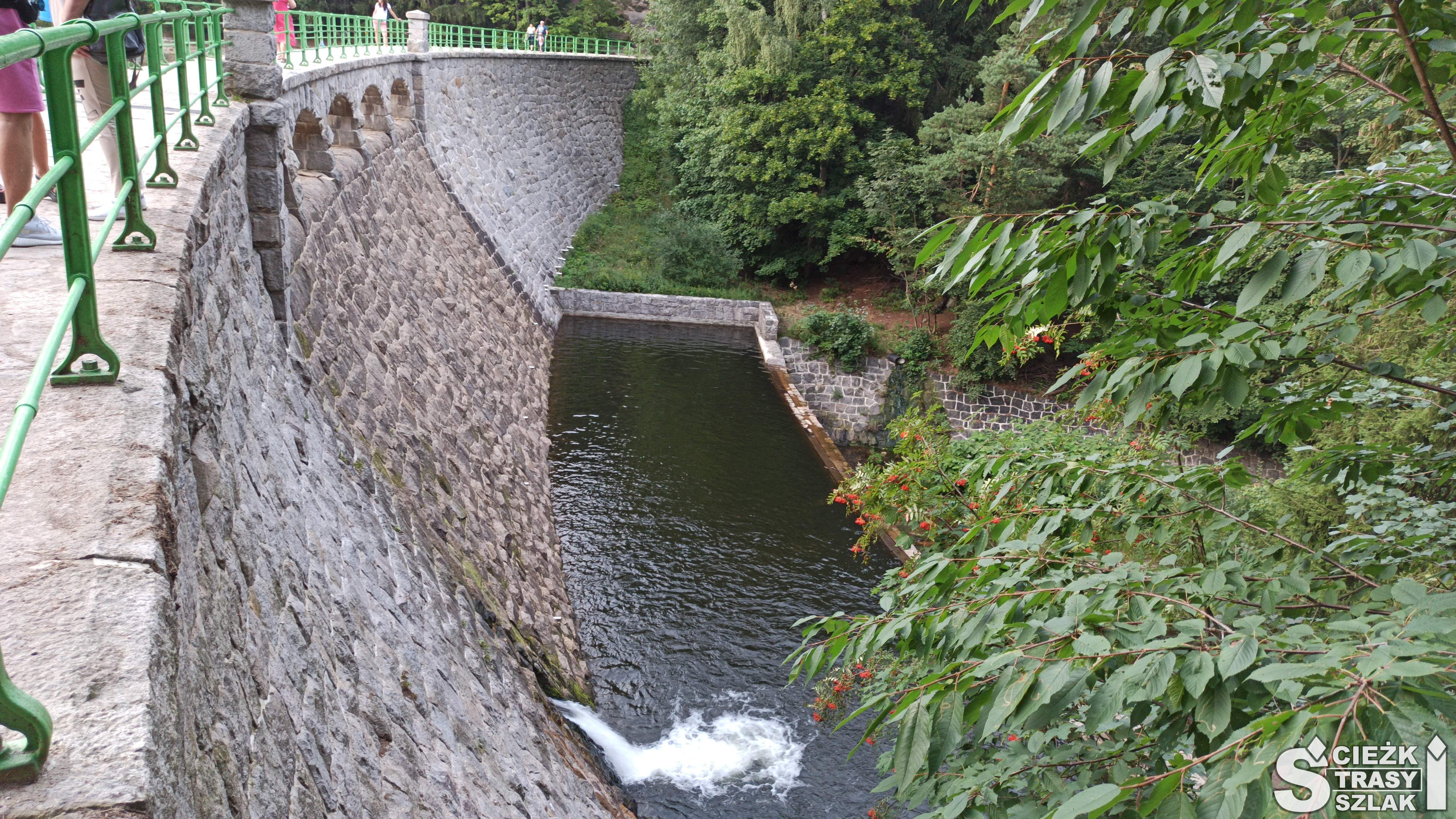 Widok na wodospad, zbiornik wodny i mostek biegnący przez Zaporę na Łomnicy w parku miejskim miasta Karpacz