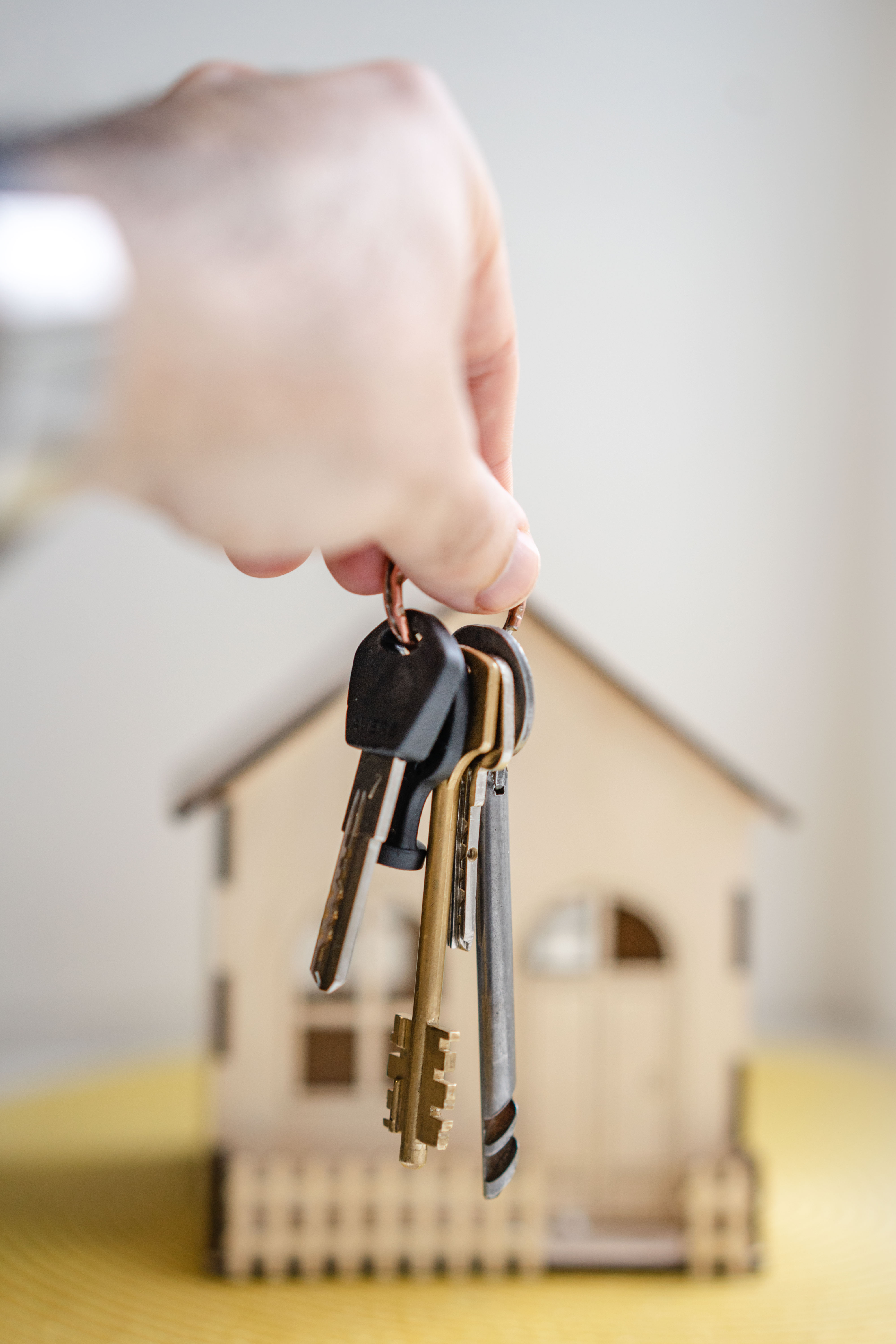 Ręka trzymająca klucze na tle domu