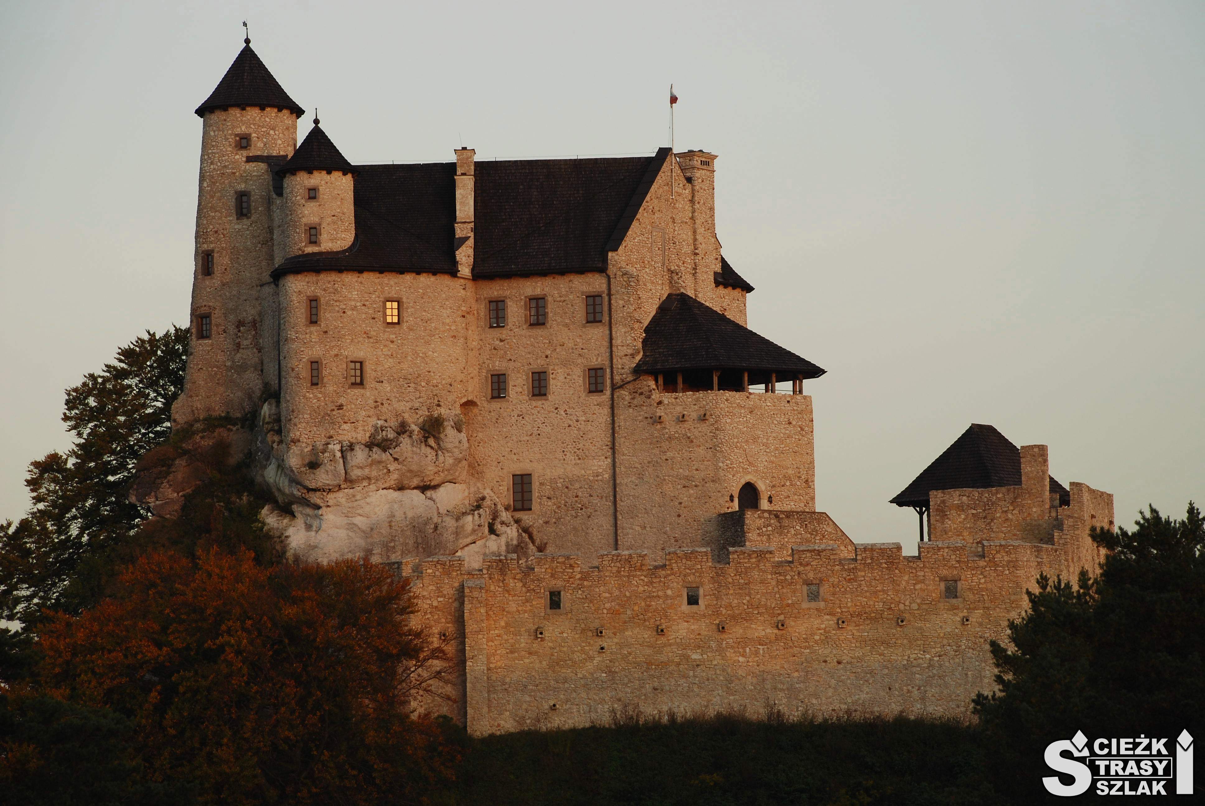 Zamek Bobolice odbudowany z ruin na skale wapiennej, z punktem widokowym, otoczony murem obronnym