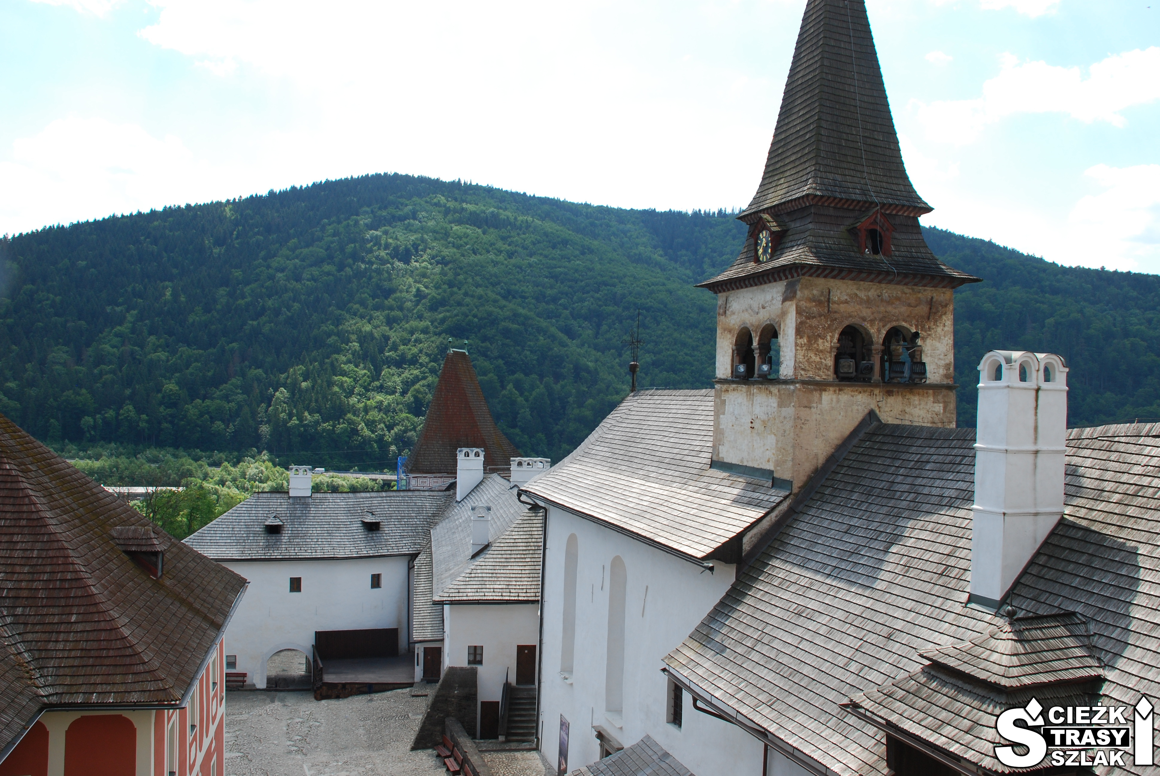 Wieża kościoła na dziedzińcu Zamku Orawskiego na Słowacji na tle wysokich gór w krainie Orawa