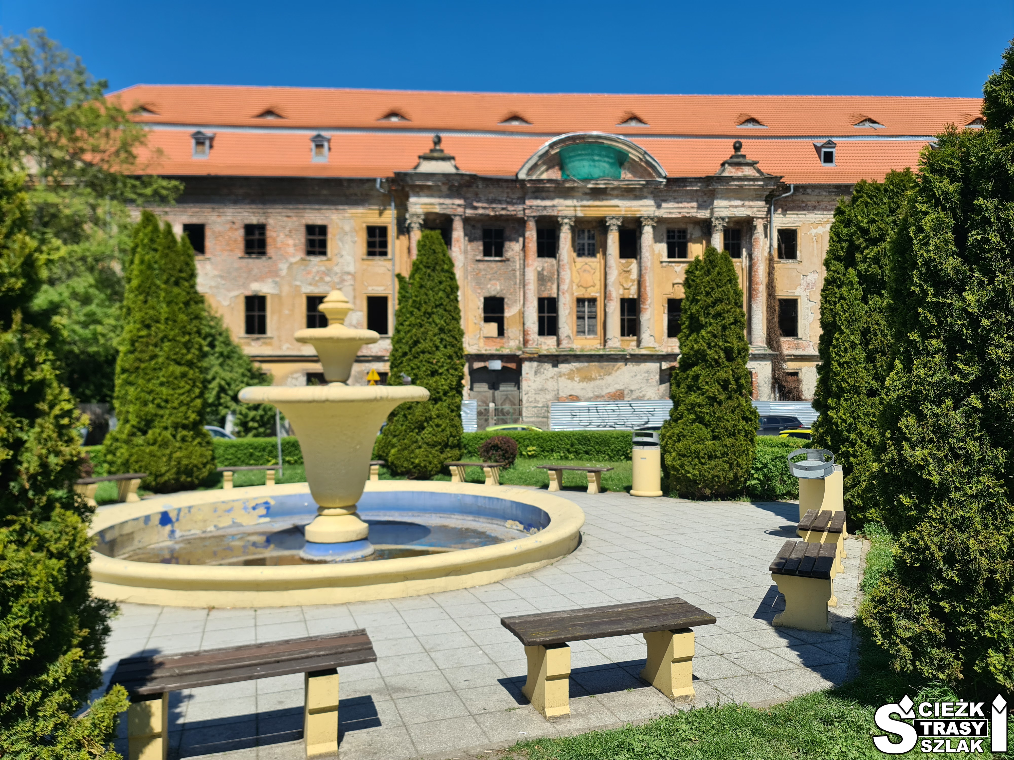 Zabytkowa fontanna w Żarach przed Pałacem Promnitzów z wysokimi kolumnami i nowym dachem