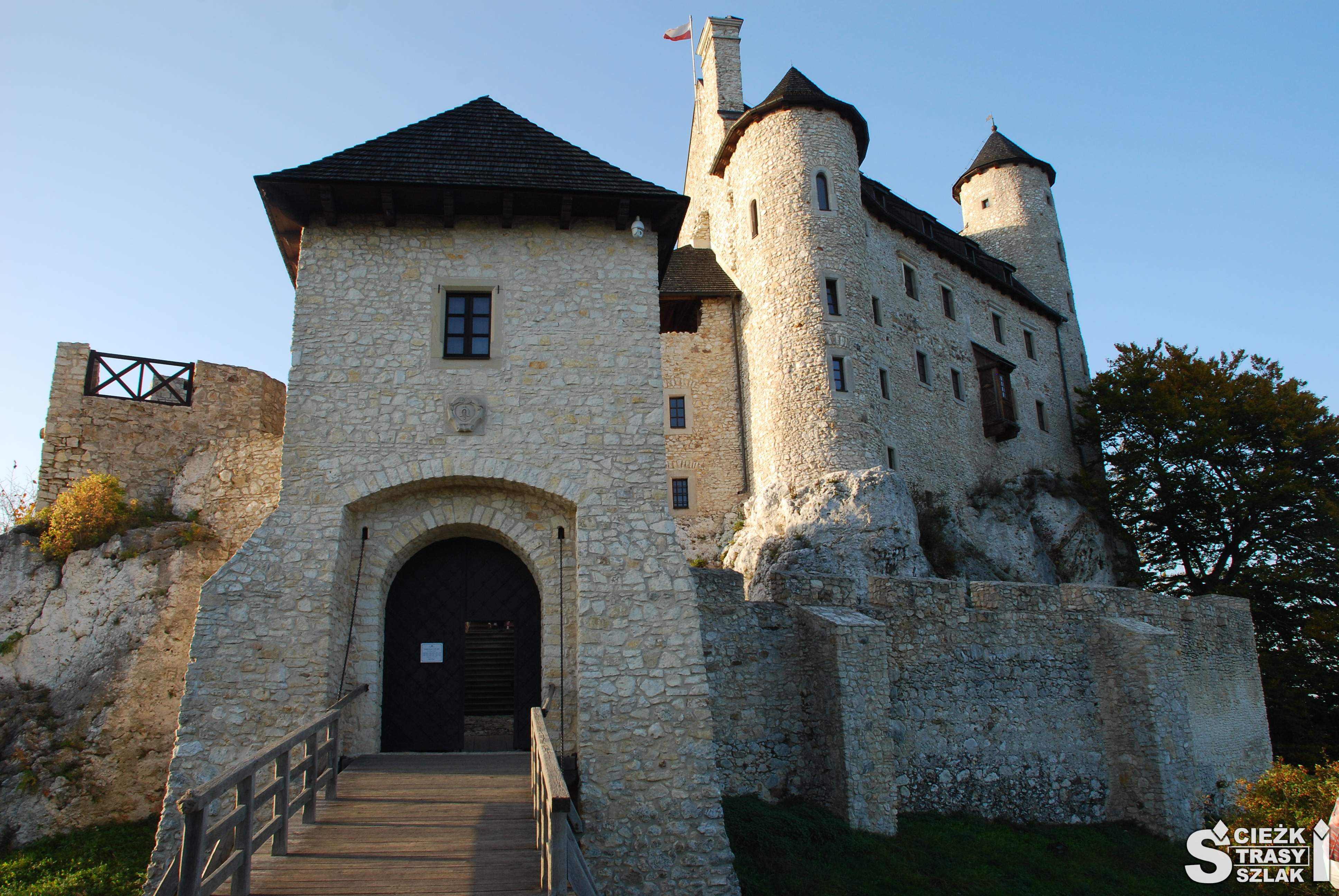 Odbudowany z ruin Zamek w Bobolicach wzniesiony na skale wapiennej od strony budynku bramnego z mostem zwodzonym