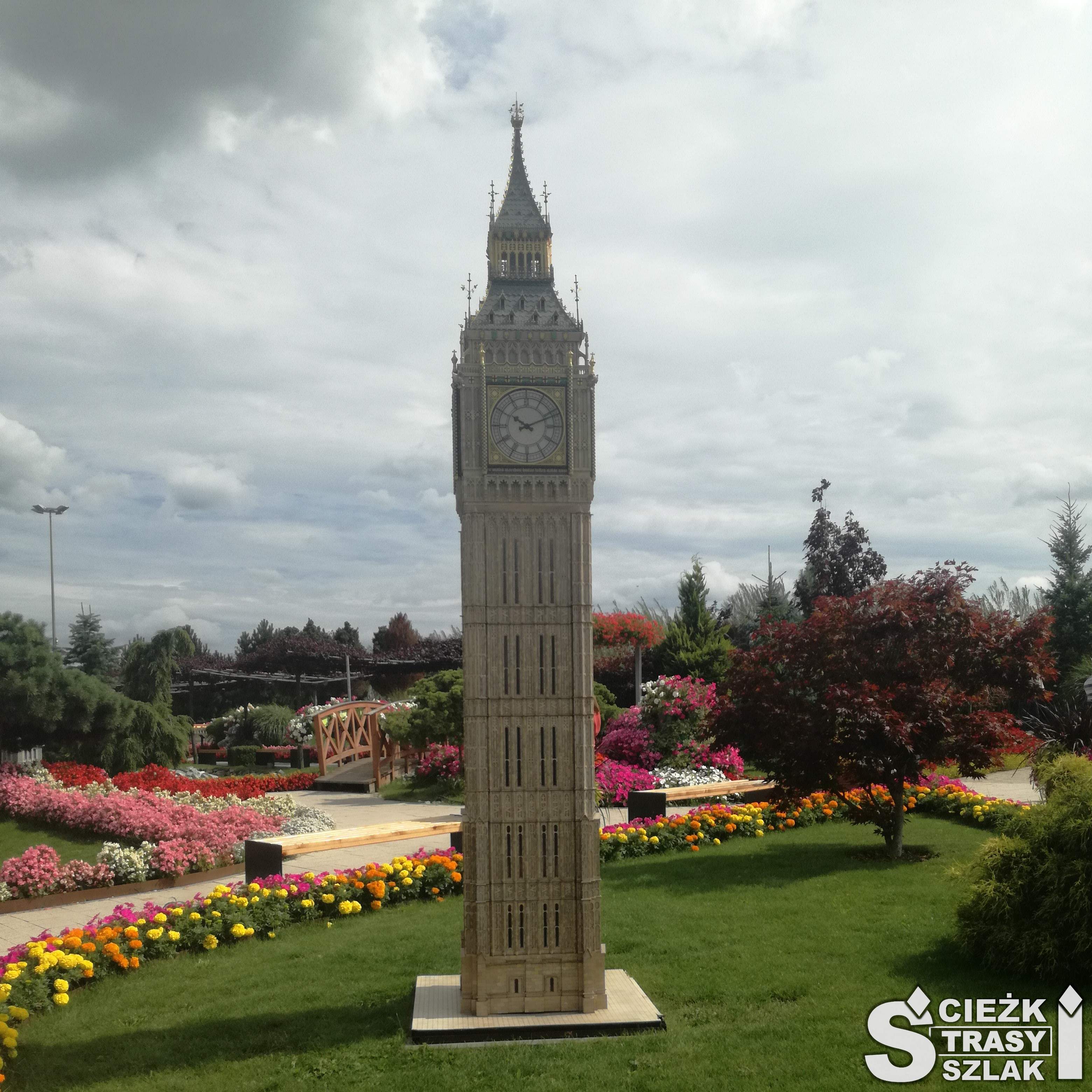 Wieża Big Ben w Parku Miniatur w Minieurolandzie w kłodzku w otoczeniu kolorowych kwiatów i krzewów