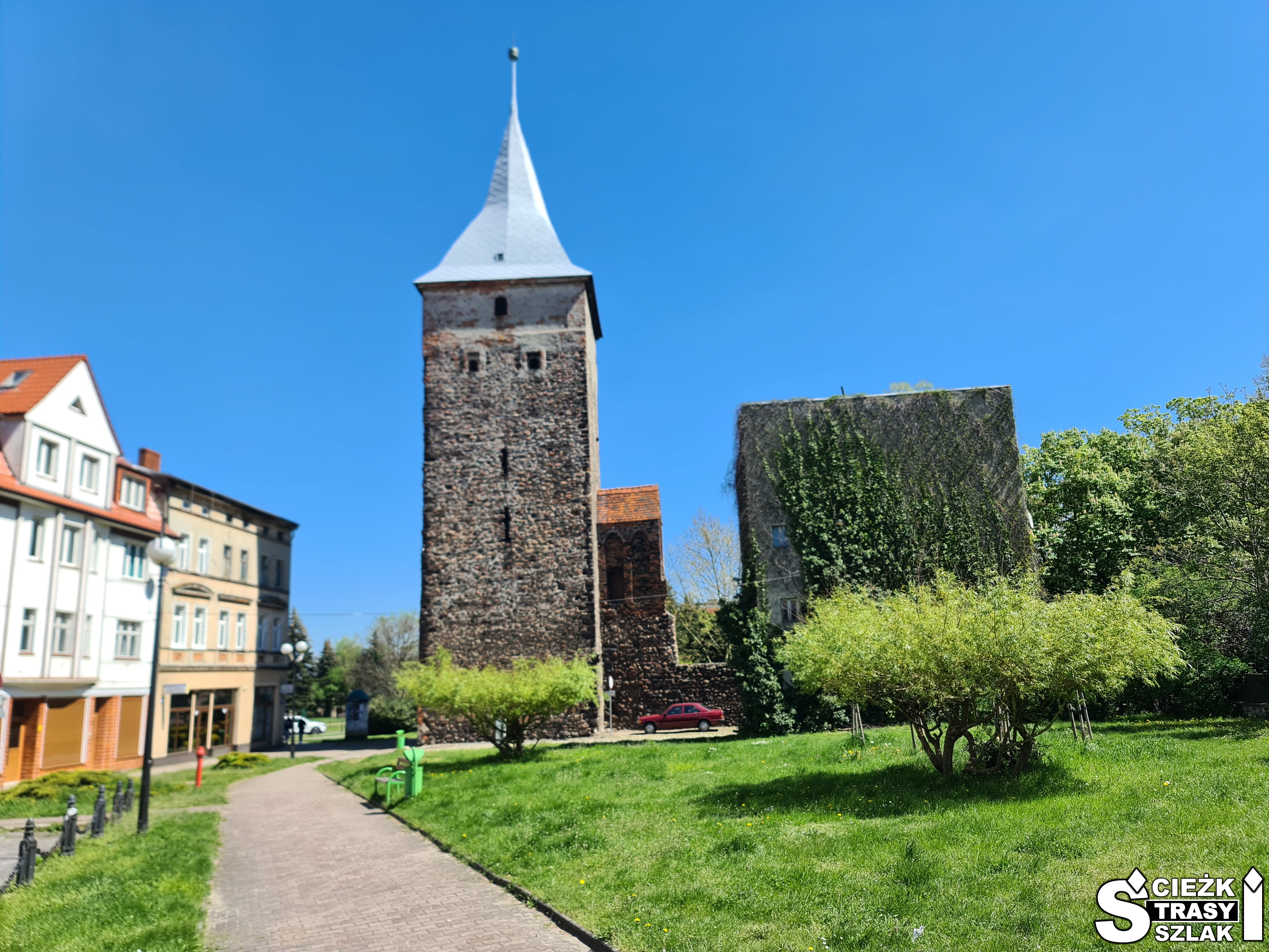 Wysoka, kwadratowa wieża wartownicza z polnych kamieni i rudy darniowej tworząca mur obronny miasta Żary