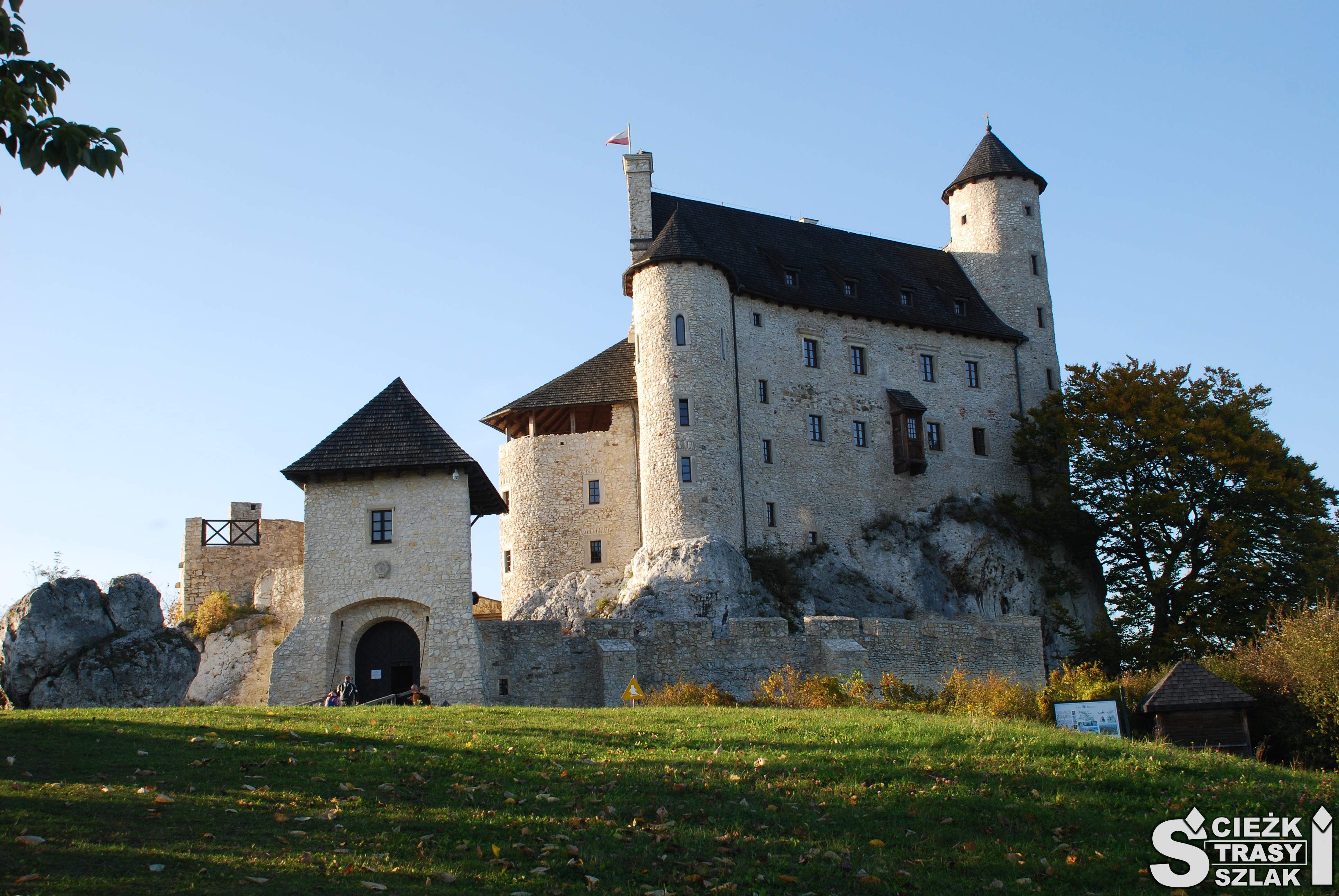 Zamek Bobolice odbudowany z ruin na skale wapiennej, z punktem widokowym, otoczony murem obronnym