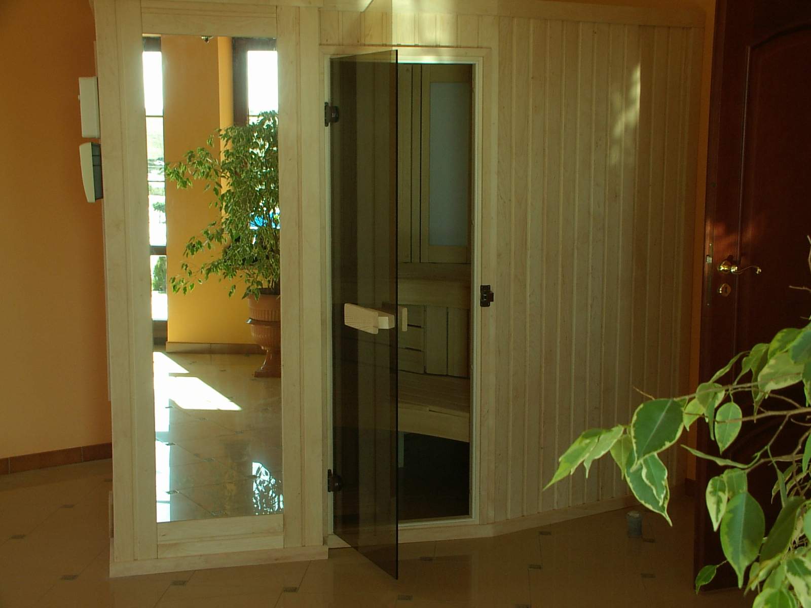sauna z eleganckiego drewna osikowego z wkomponowanym lustrem i szklanymi drzwiami